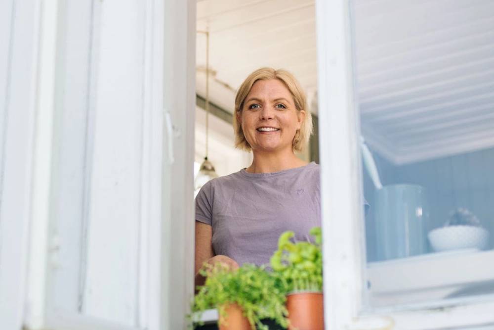 Kvinne som ser ut av vindu.