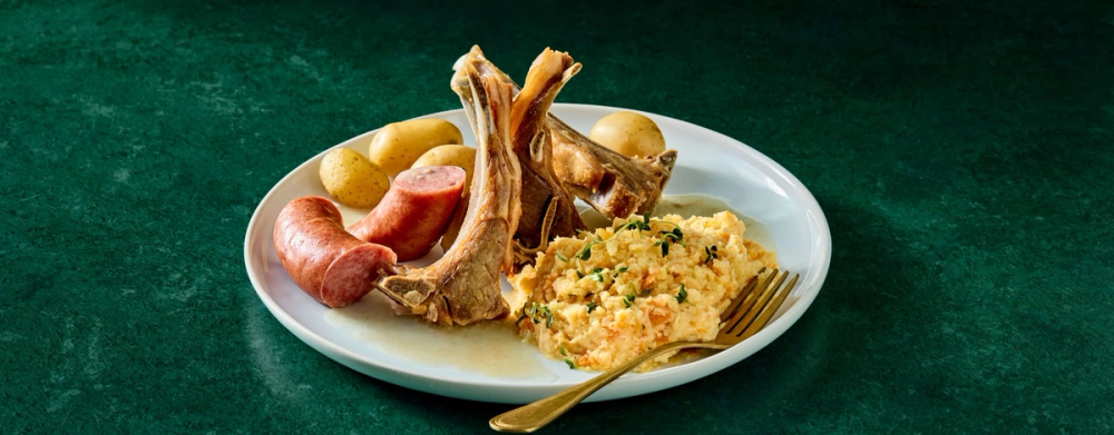 Tallerken med pinnekjøtt med kålrotstappe, poteter og vossakorv.