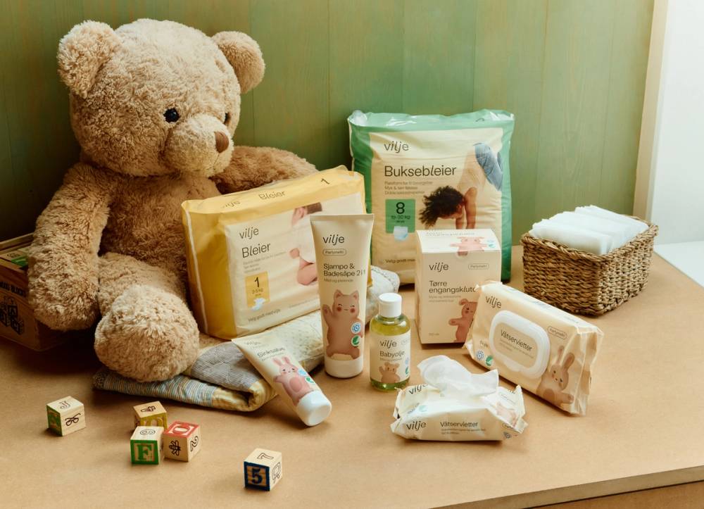 Teddybjørn og ulike Vilje-produkter til baby, som bleier, våtservietter og babyolje.
