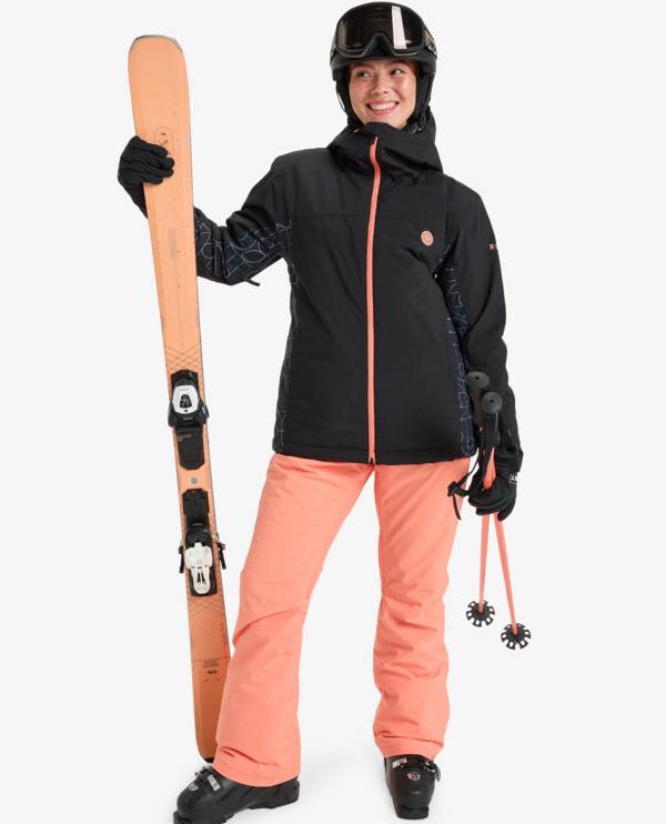Woman smiling with skis, a black ski coat with pink zip and pink ski trousers