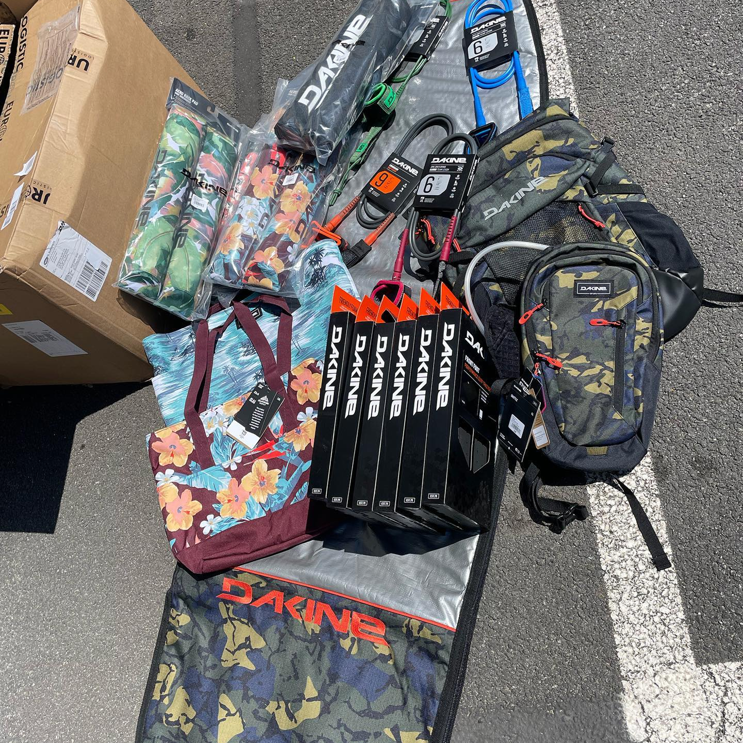 Surfboard and accessories laid our on the floor outside
