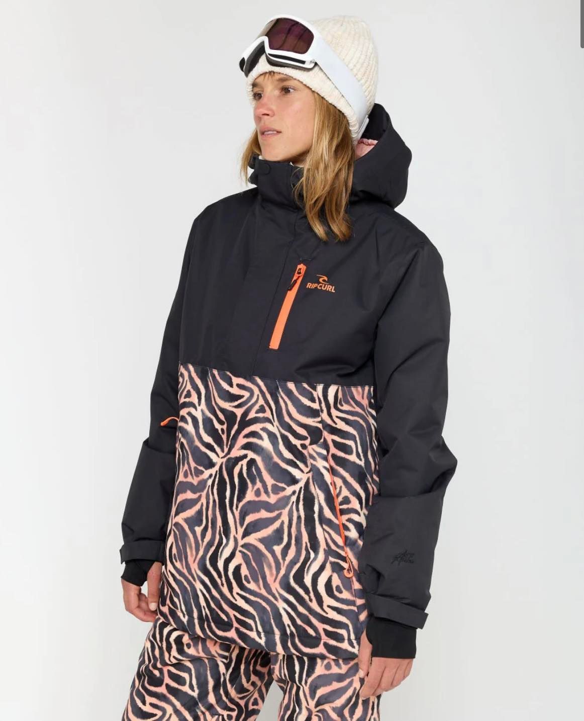 Woman in white hat goggles, black and pink pattern coat