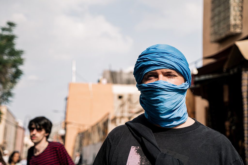 Un homme au foulard bleu dans une rue