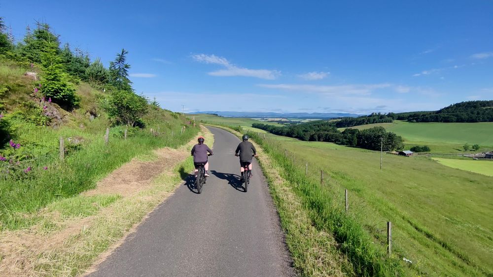 The view over Strathearn two cyclists on a narrow country road with a view over countryside