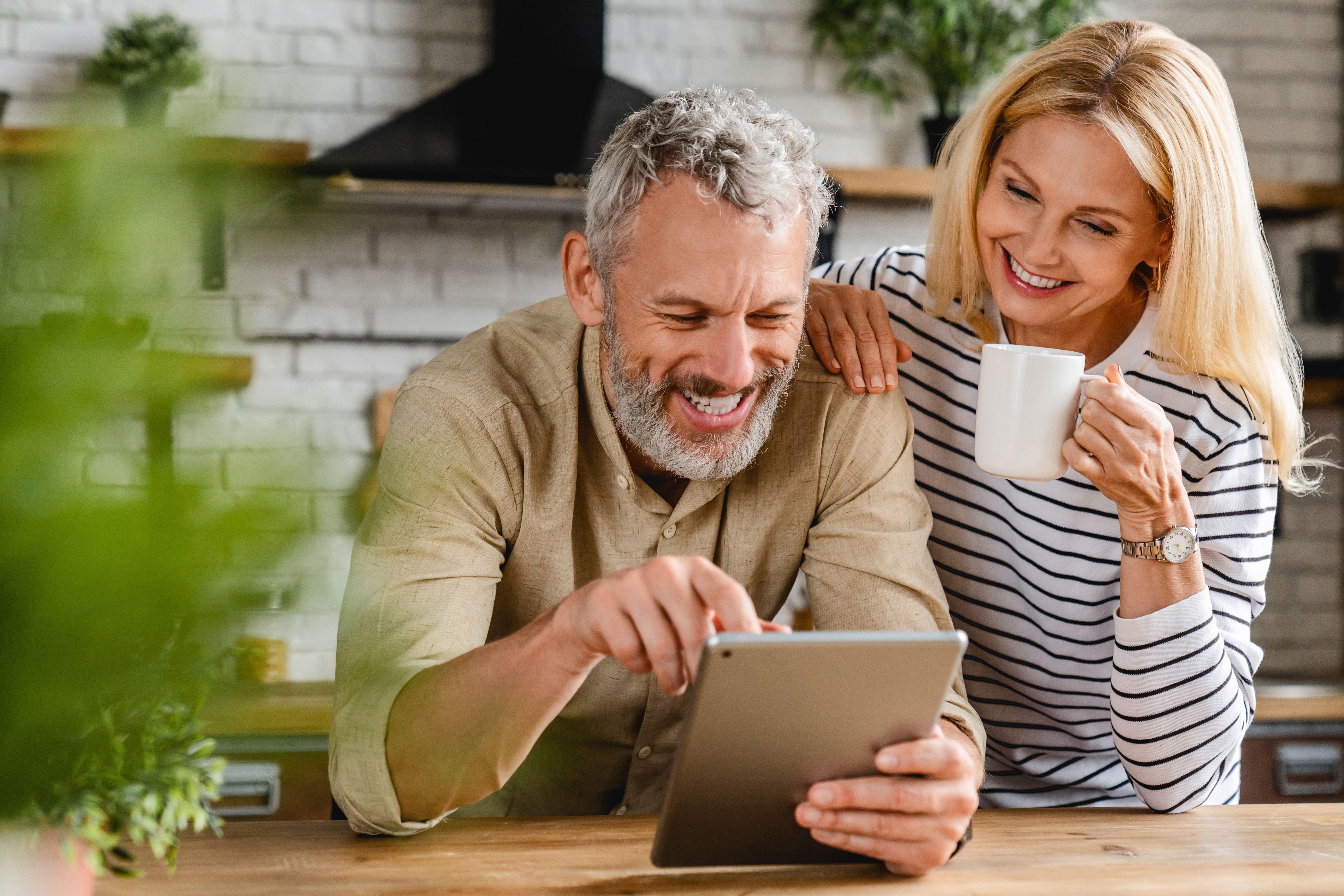 Couple in kitchen researching personal insurance 