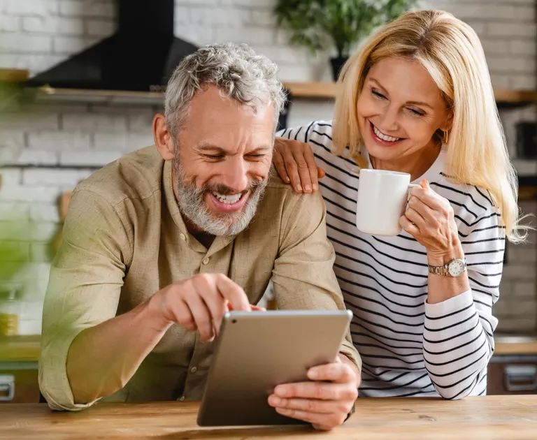 Couple in kitchen researching personal insurance