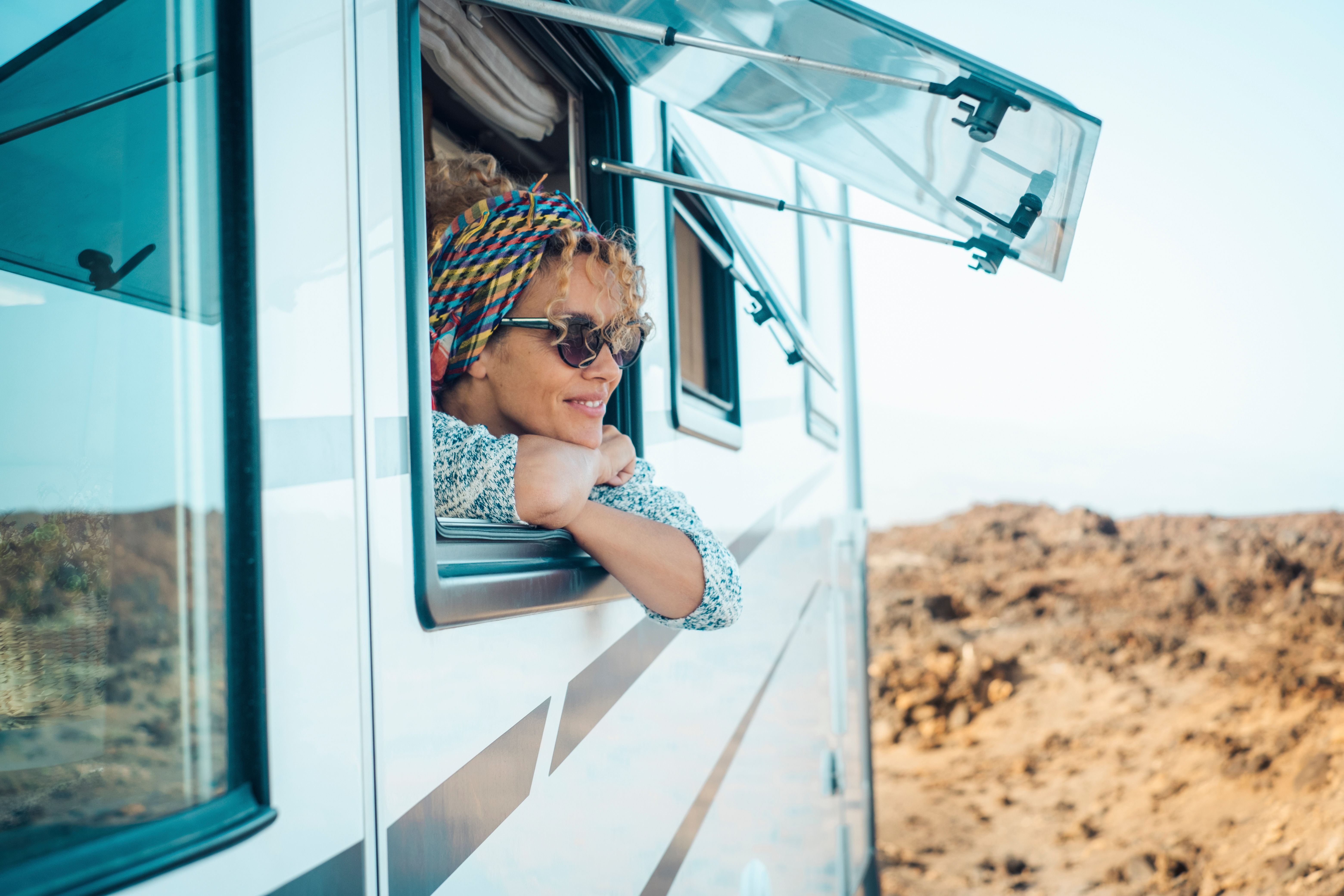 woman looking out window of her caravan smiling