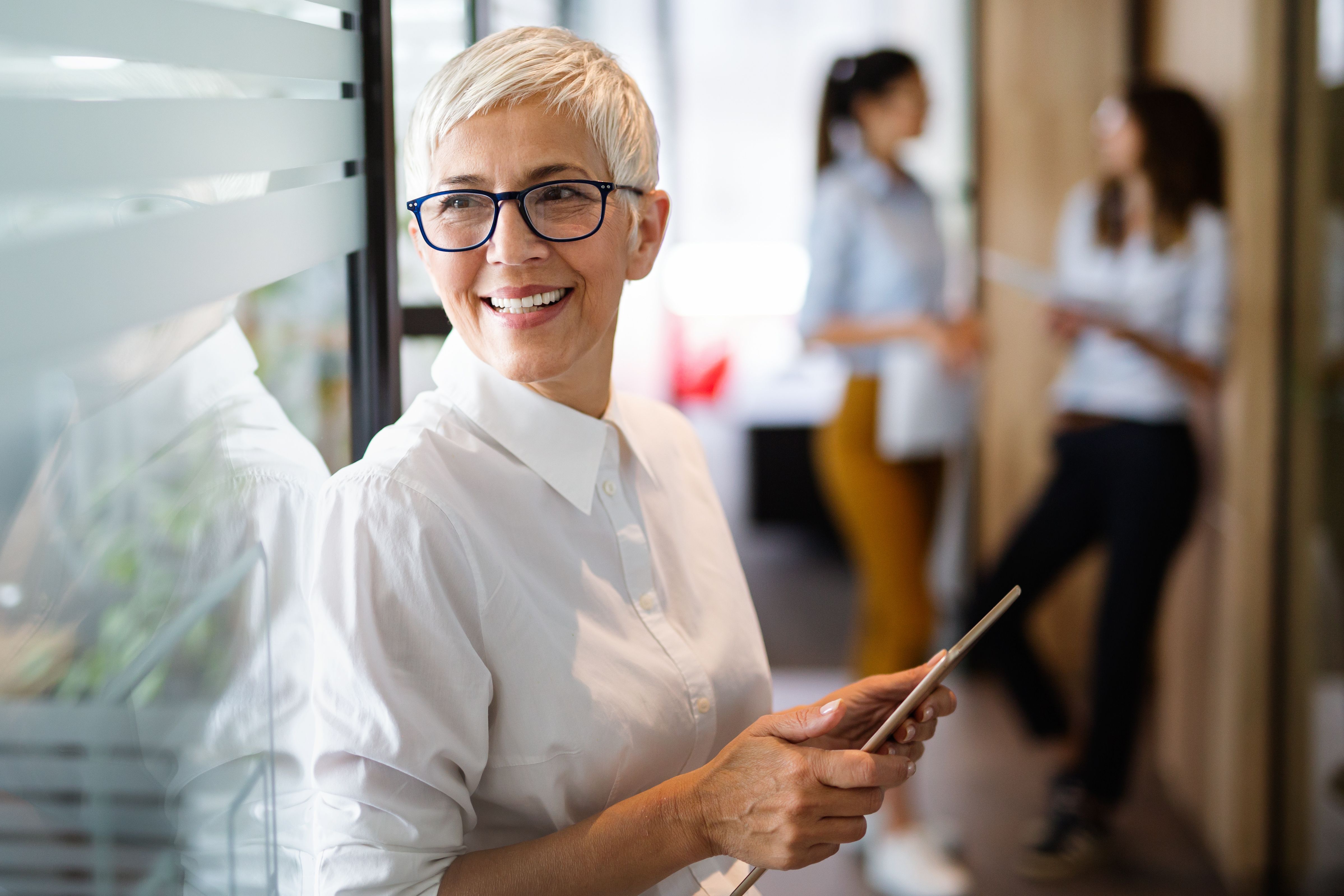 woman in office holding laptop