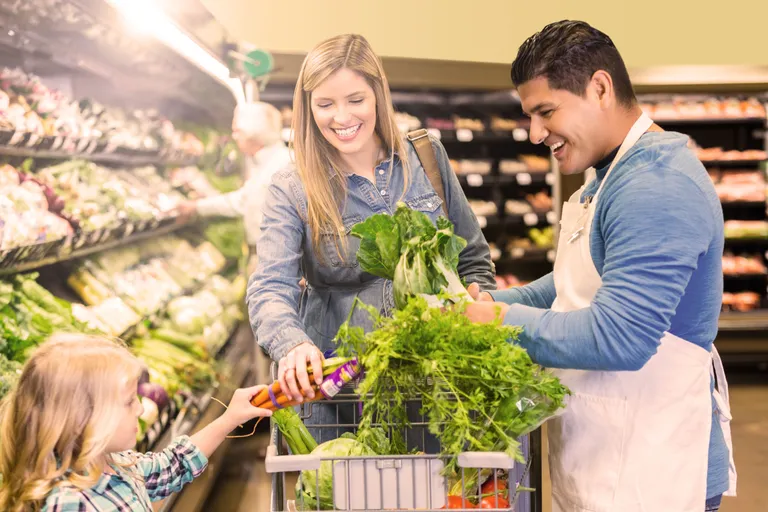 Mom shopping for vegetables at grocery store