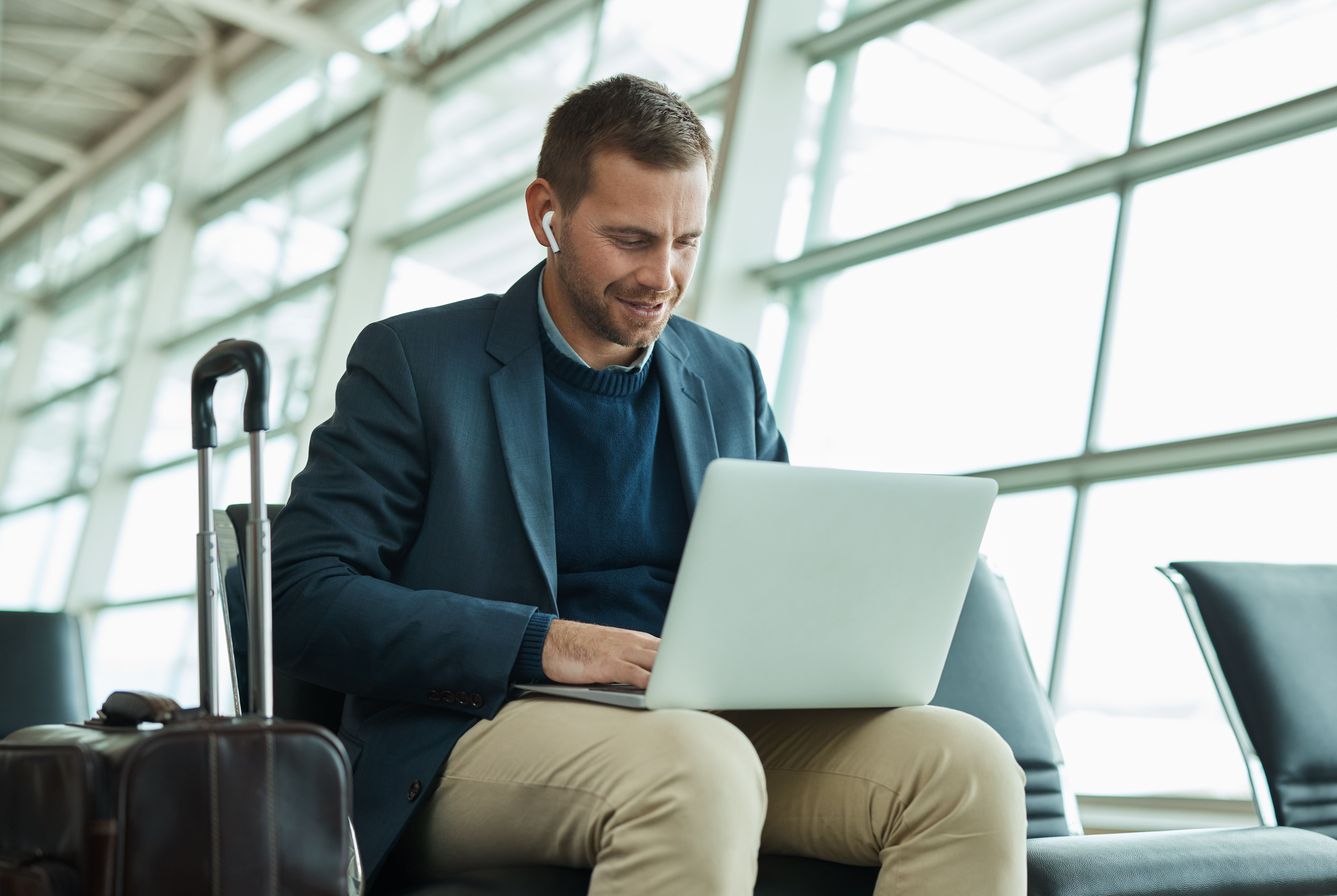 man on laptop sitting at airport