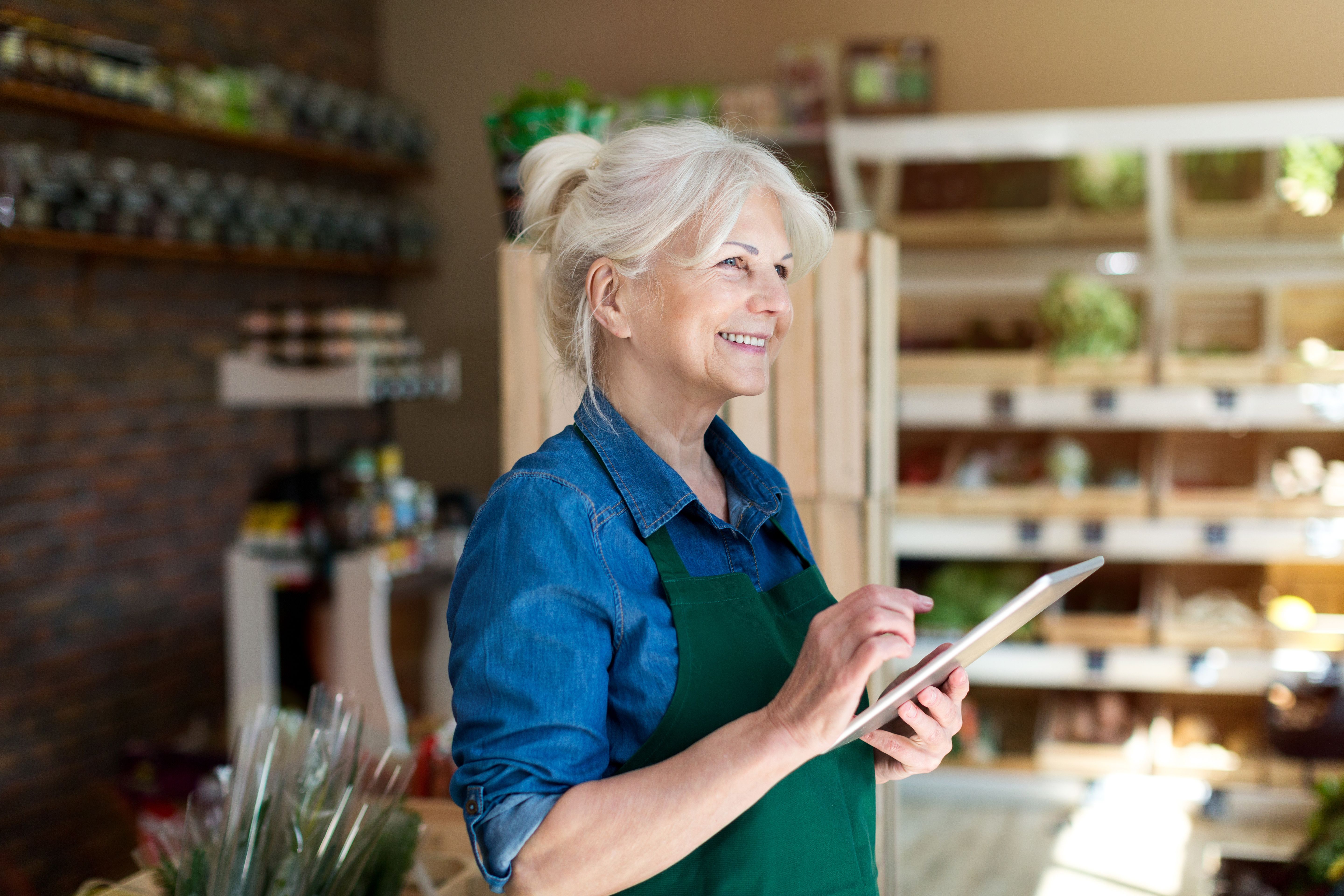 Lady working in grocery store holding ipad