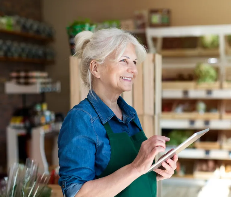 Lady working in grocery store holding ipad
