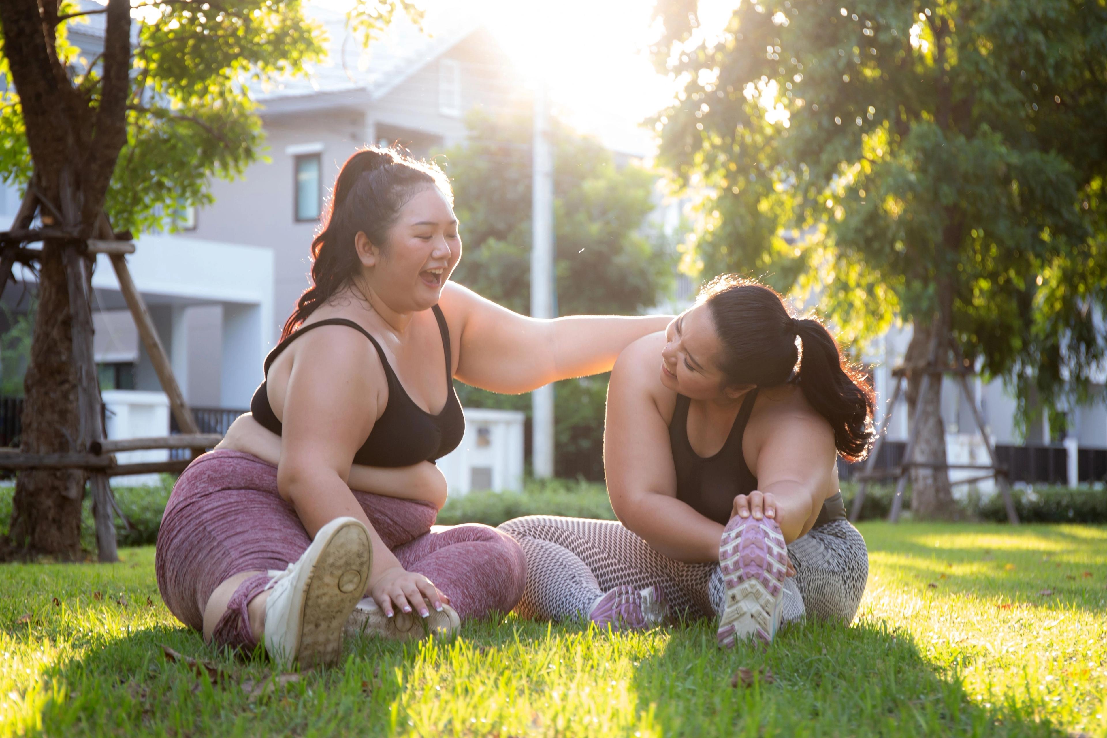 Two female family members stretching in a park