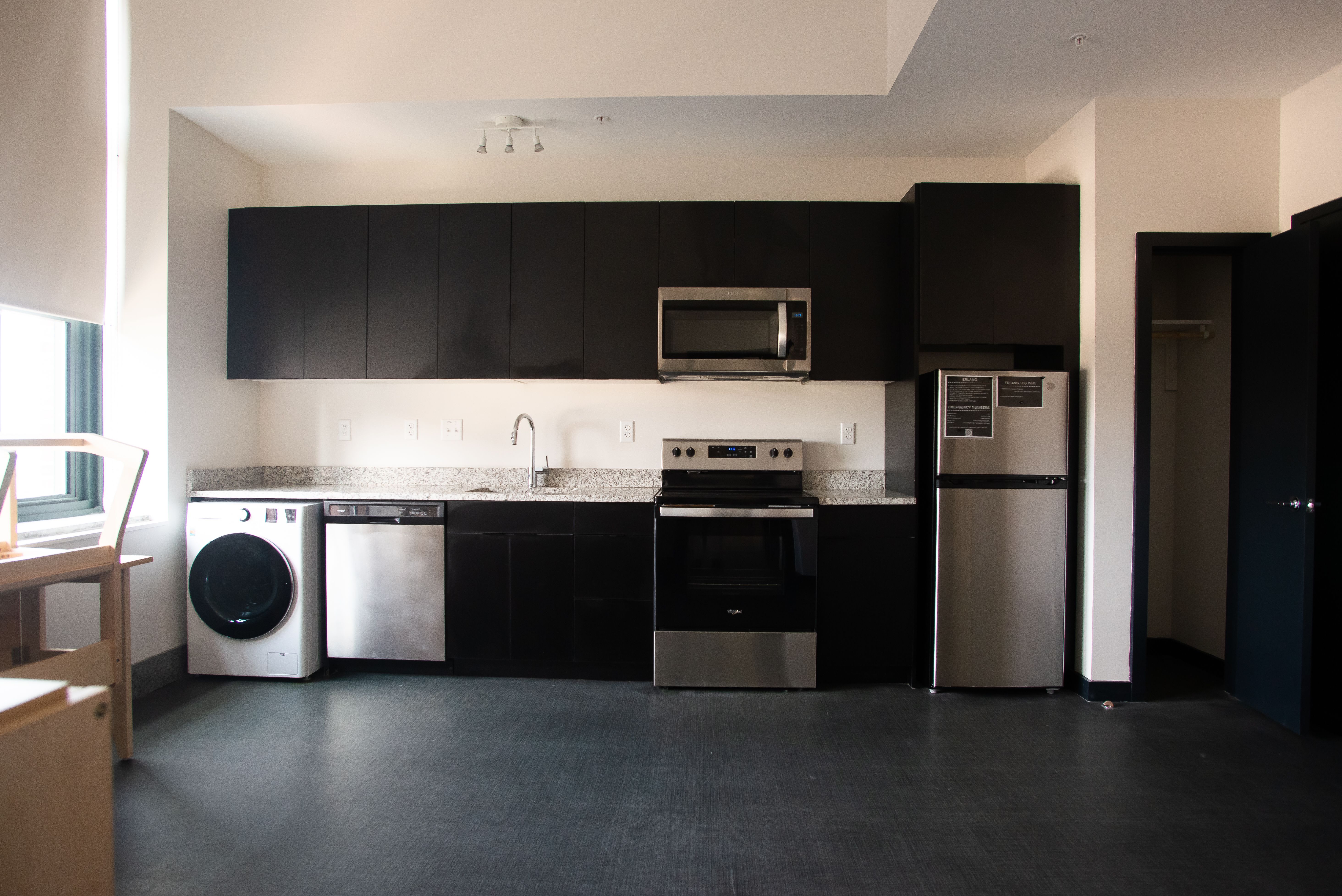 View of an Erlang dorm kitchen with a stove and oven, washer/dryer, and refrigerator