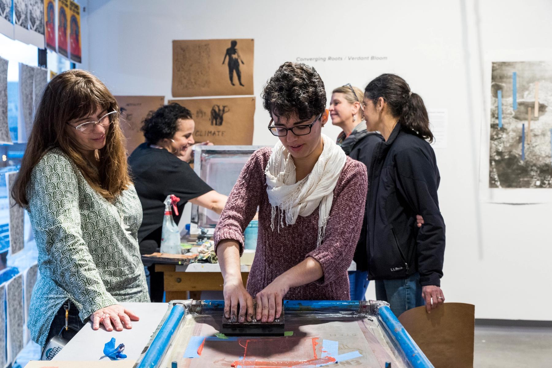 A group of people screenprinting.
