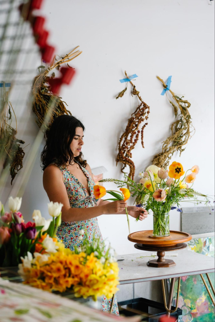 Jodi Ferry arranging a vase of flowers.