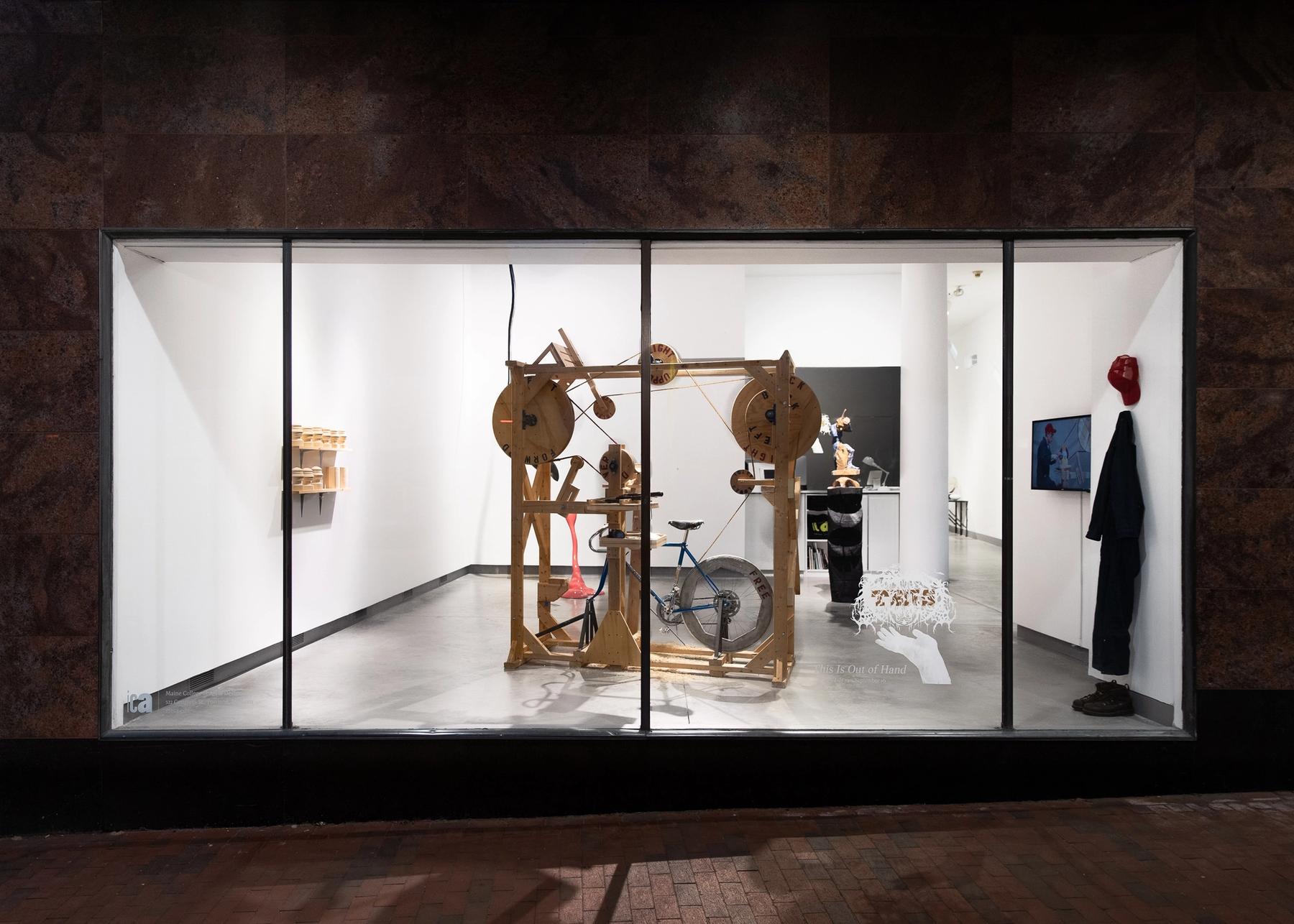 View of a wooden kinetic sculpture in the ICA windows.