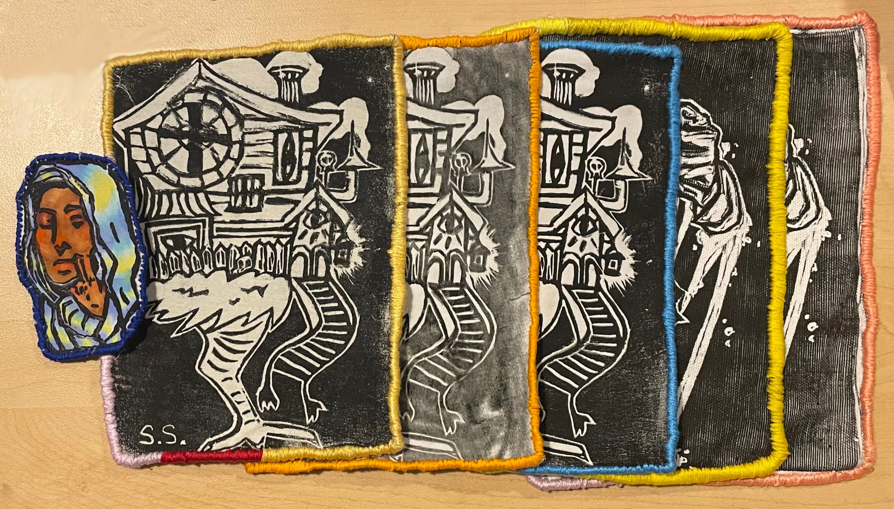 A series of patches with imagery of a house walking on bird legs.