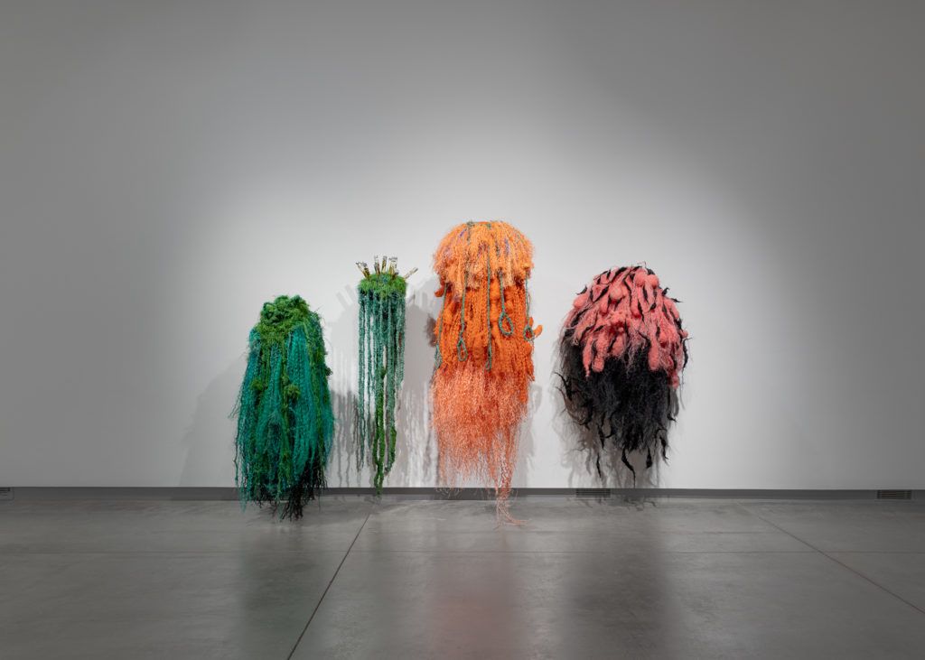 Four jellyfish-like figures made from fiber.