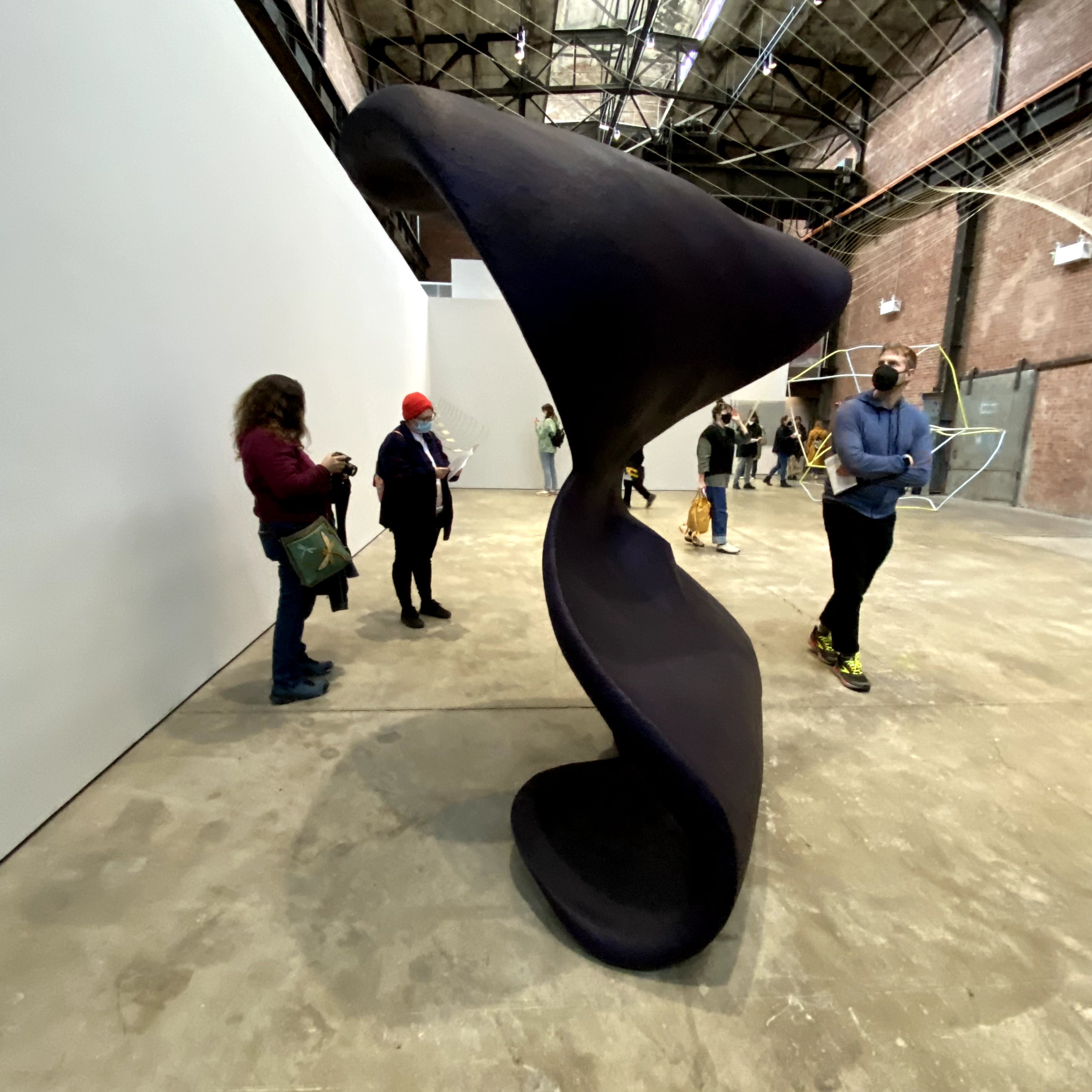 MFA students looking at a large sculpture.
