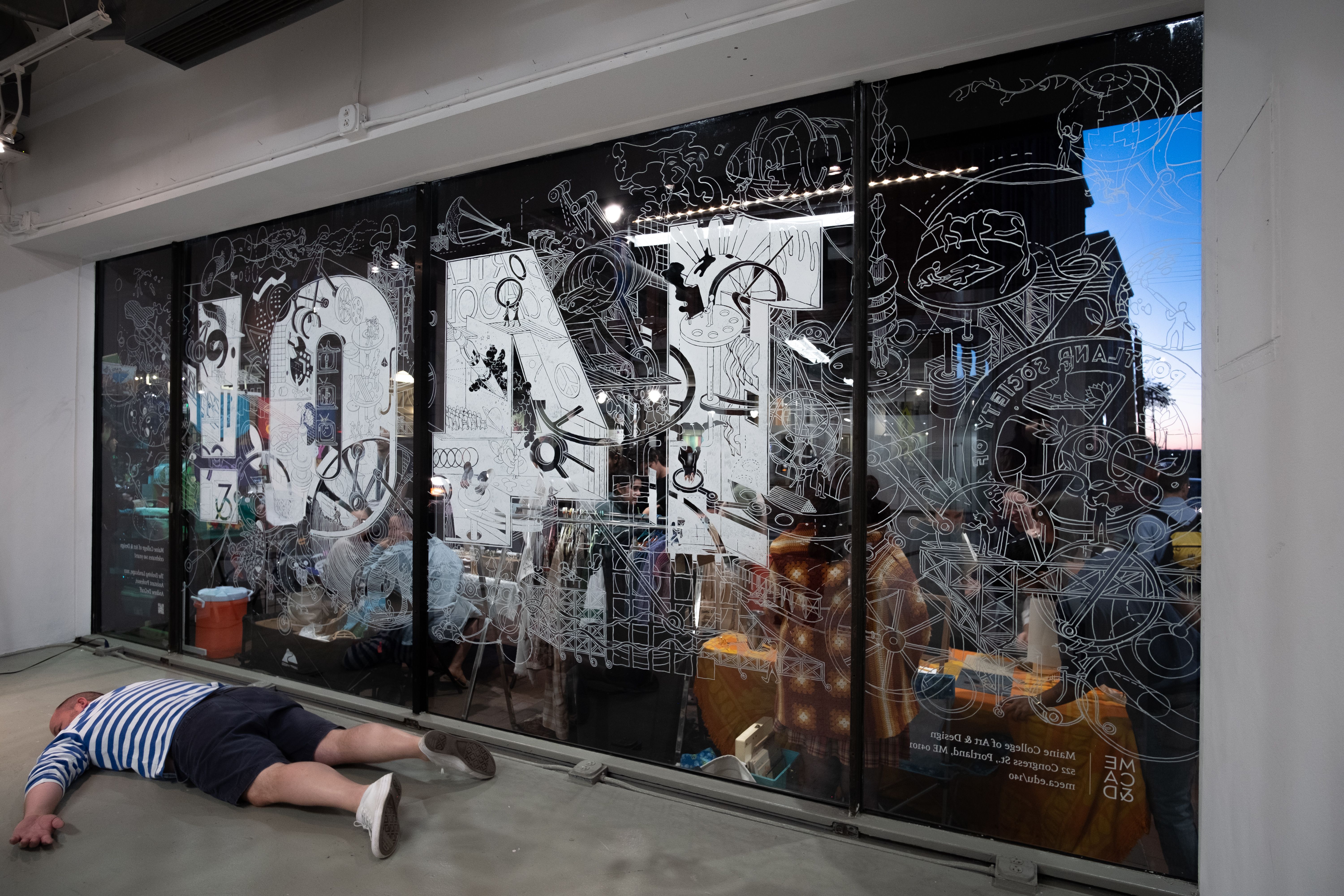 A detailed window drawing a backwards 140! with the artist collapsed on the floor.