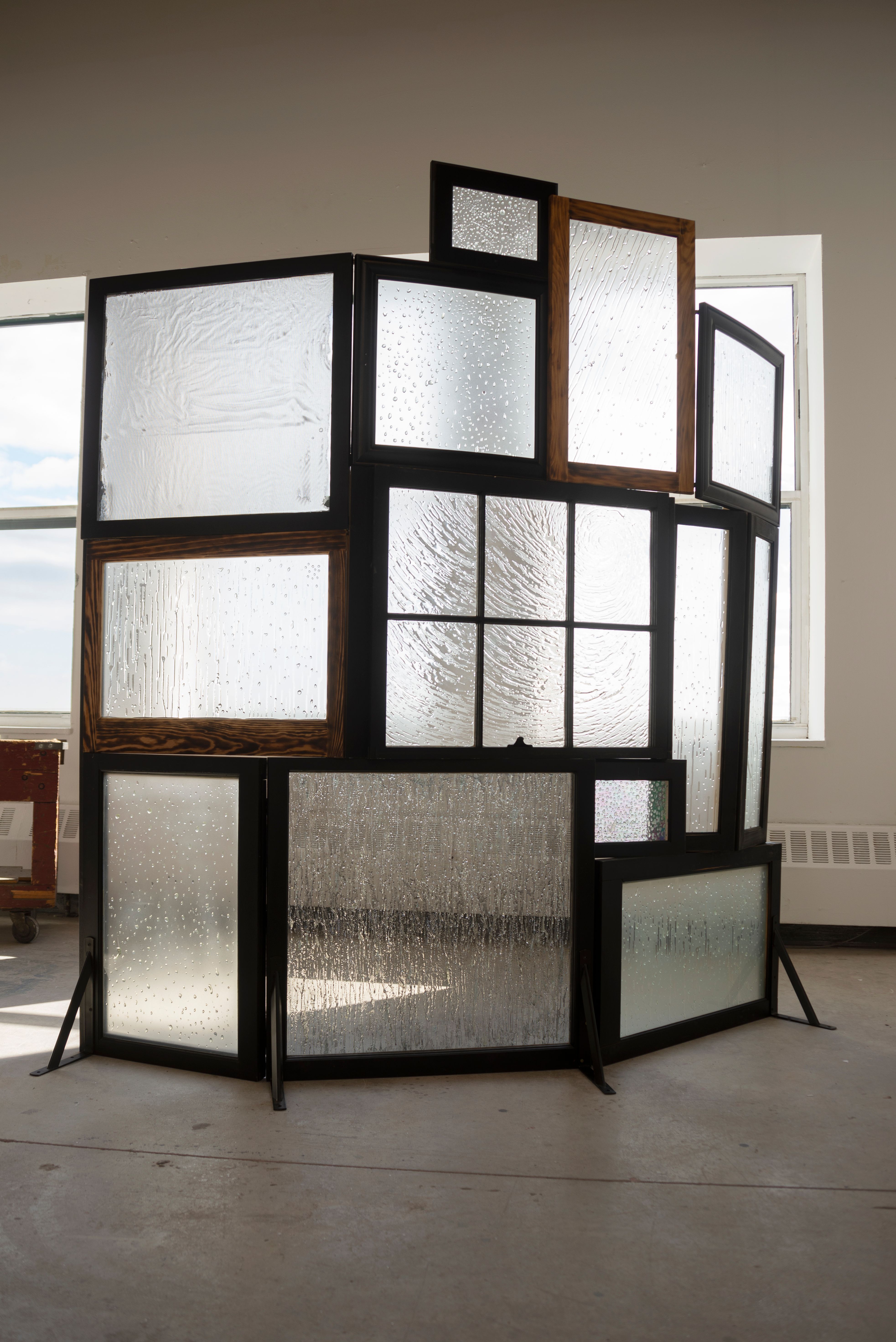 A sculpture of stacked, frosted, framed windows.