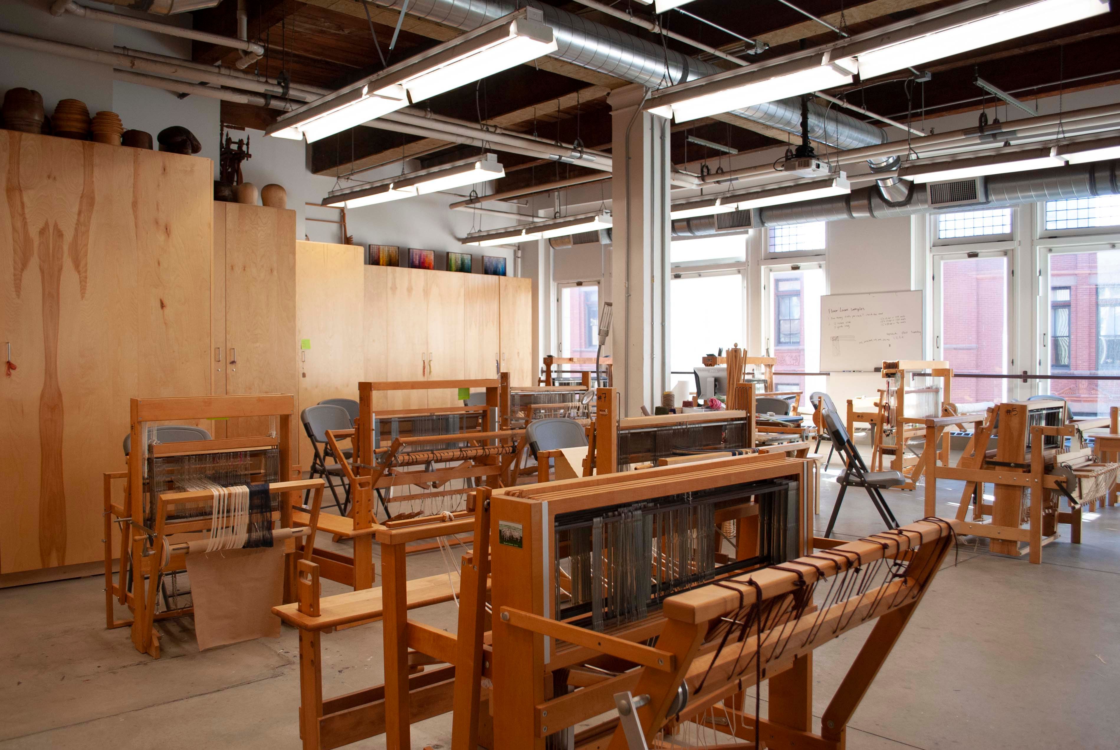 Textile and Fashion Design studio with many wooden looms wet up for weaving.