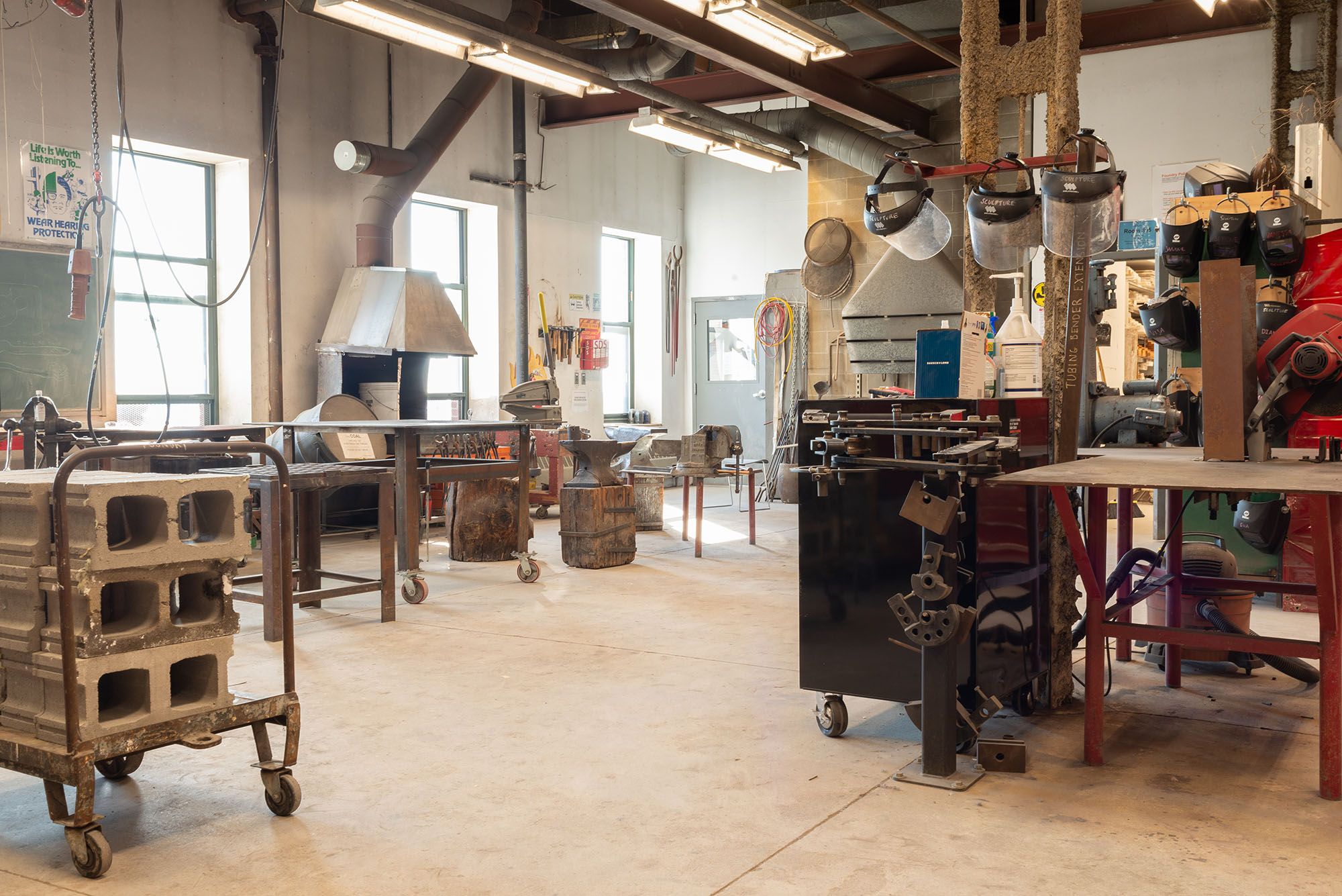 View of the sculpture studio with an anvil, forage, and concrete blocks.