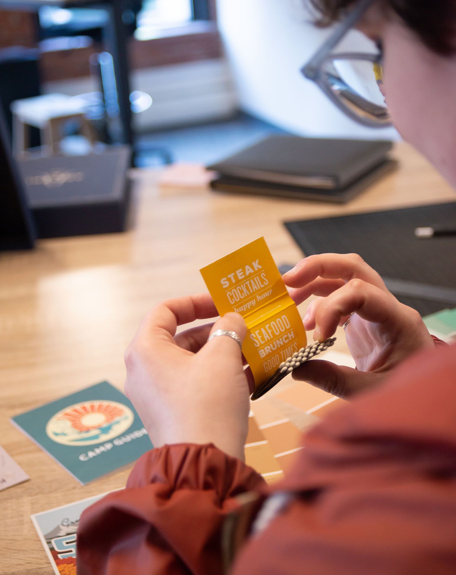 A student opening a branded yellow matchbook during a studio visit.