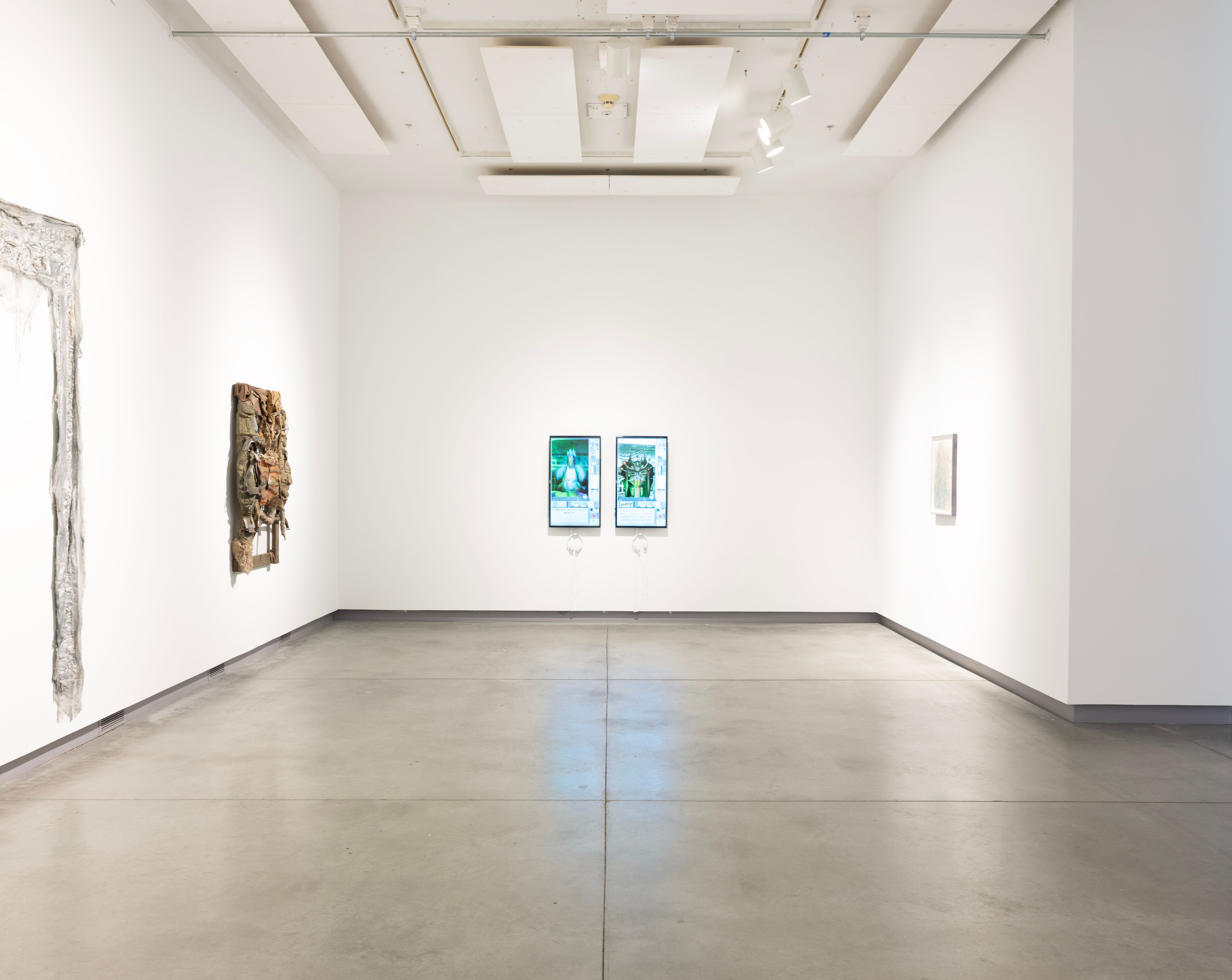 ENTER: installation view of two screens, two sculptures hanging on the wall, and a framed piece.