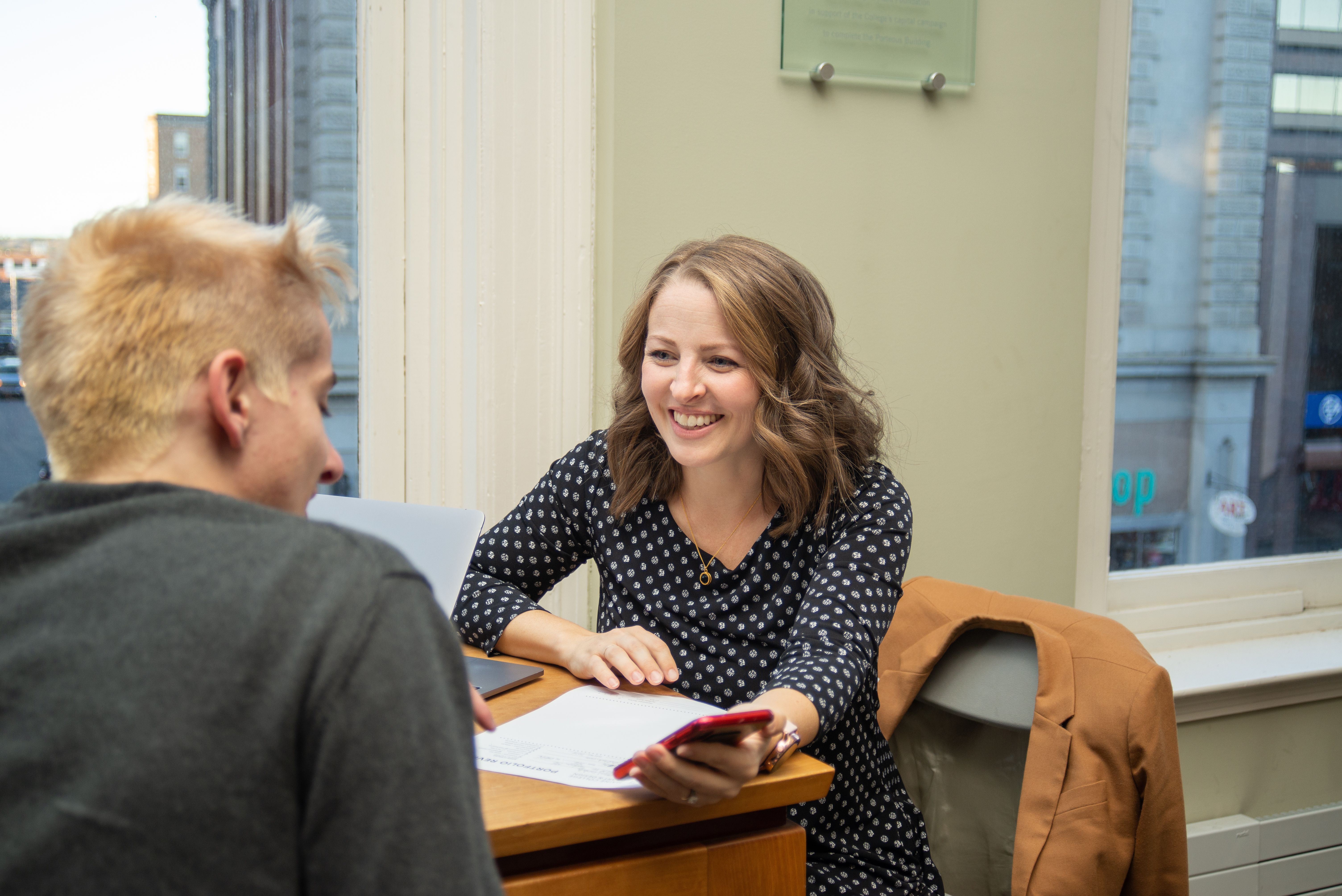 A prospective student talking with an admissions counselor during an open house.