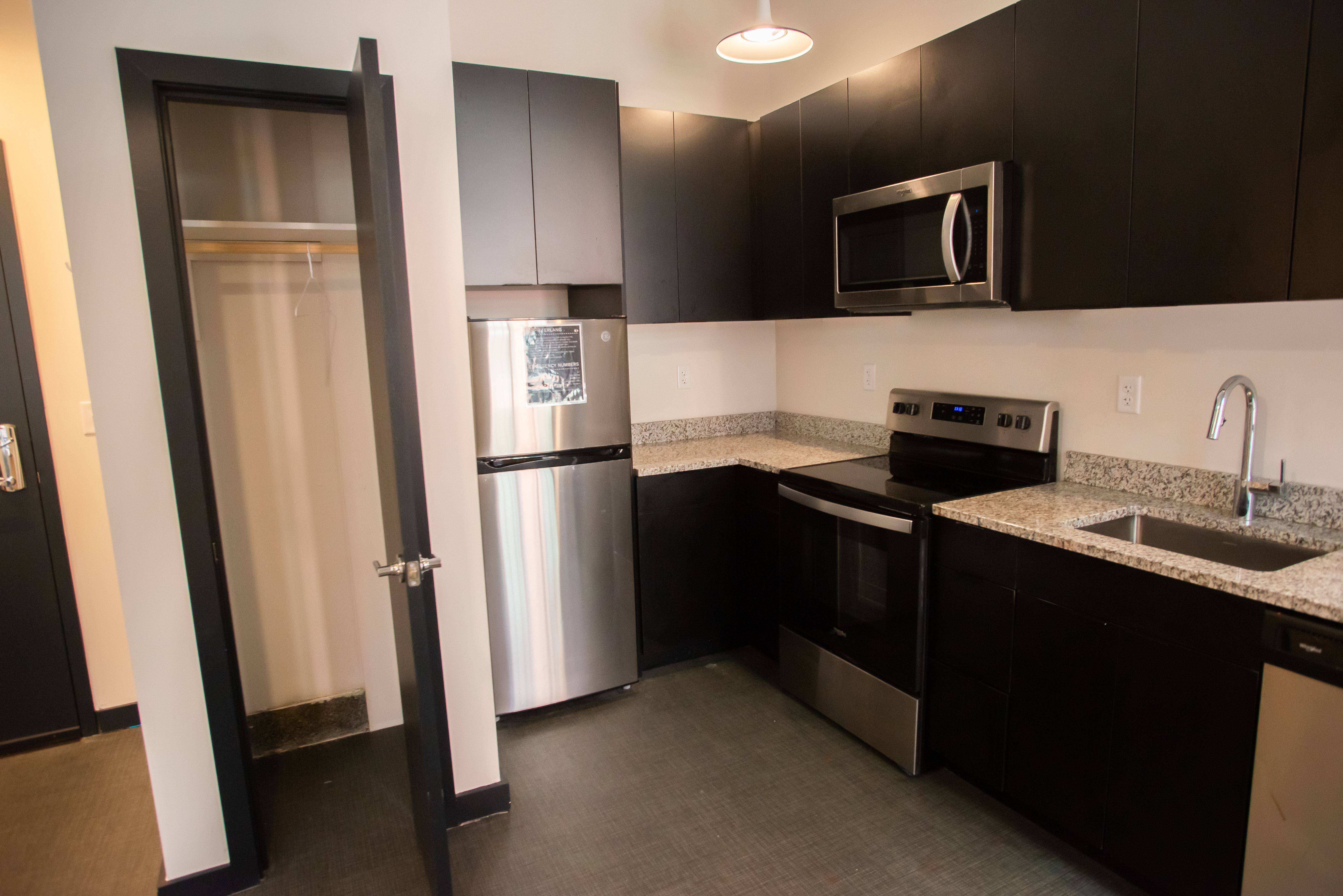 View of an Erlang dorm kitchen with a microwave, stove/oven, and large closet.