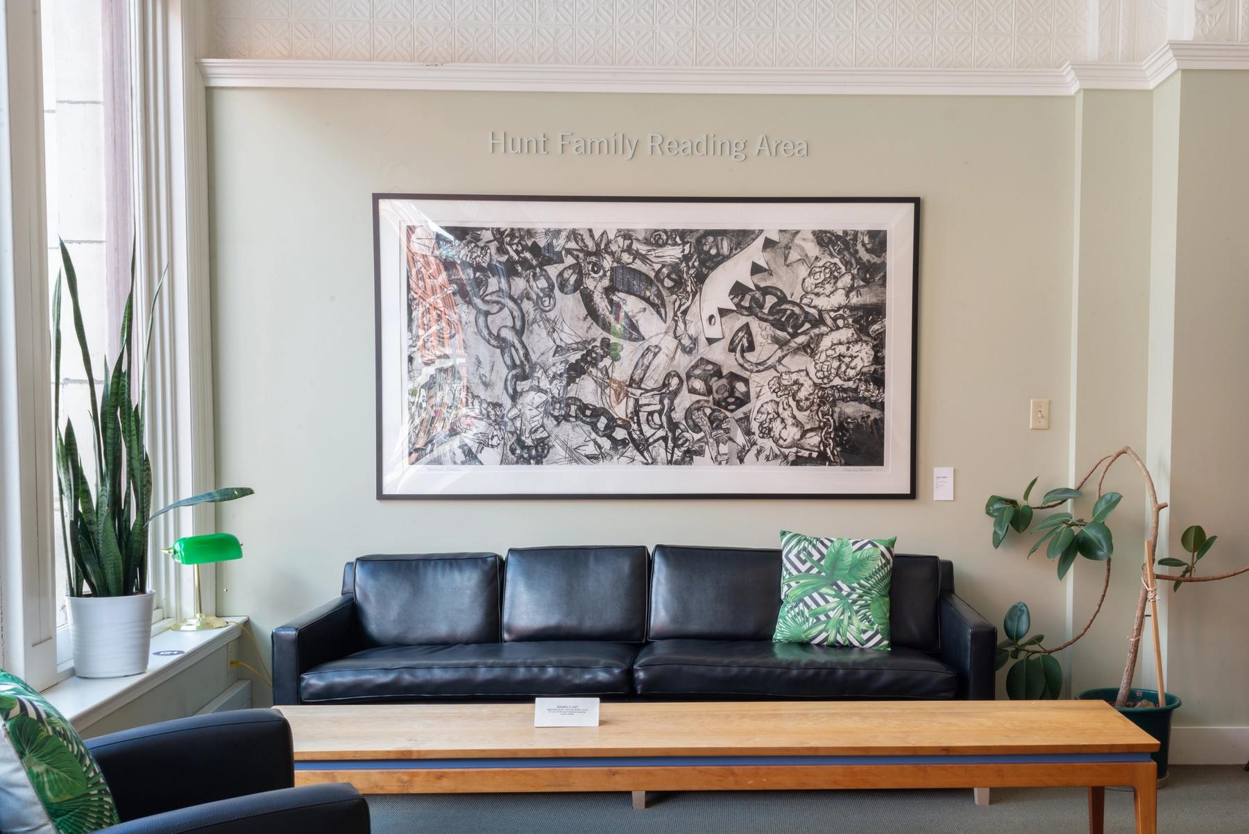 View of the Hunt Family Reading Area in the library, with comfy chairs, a couch, and a coffee table.