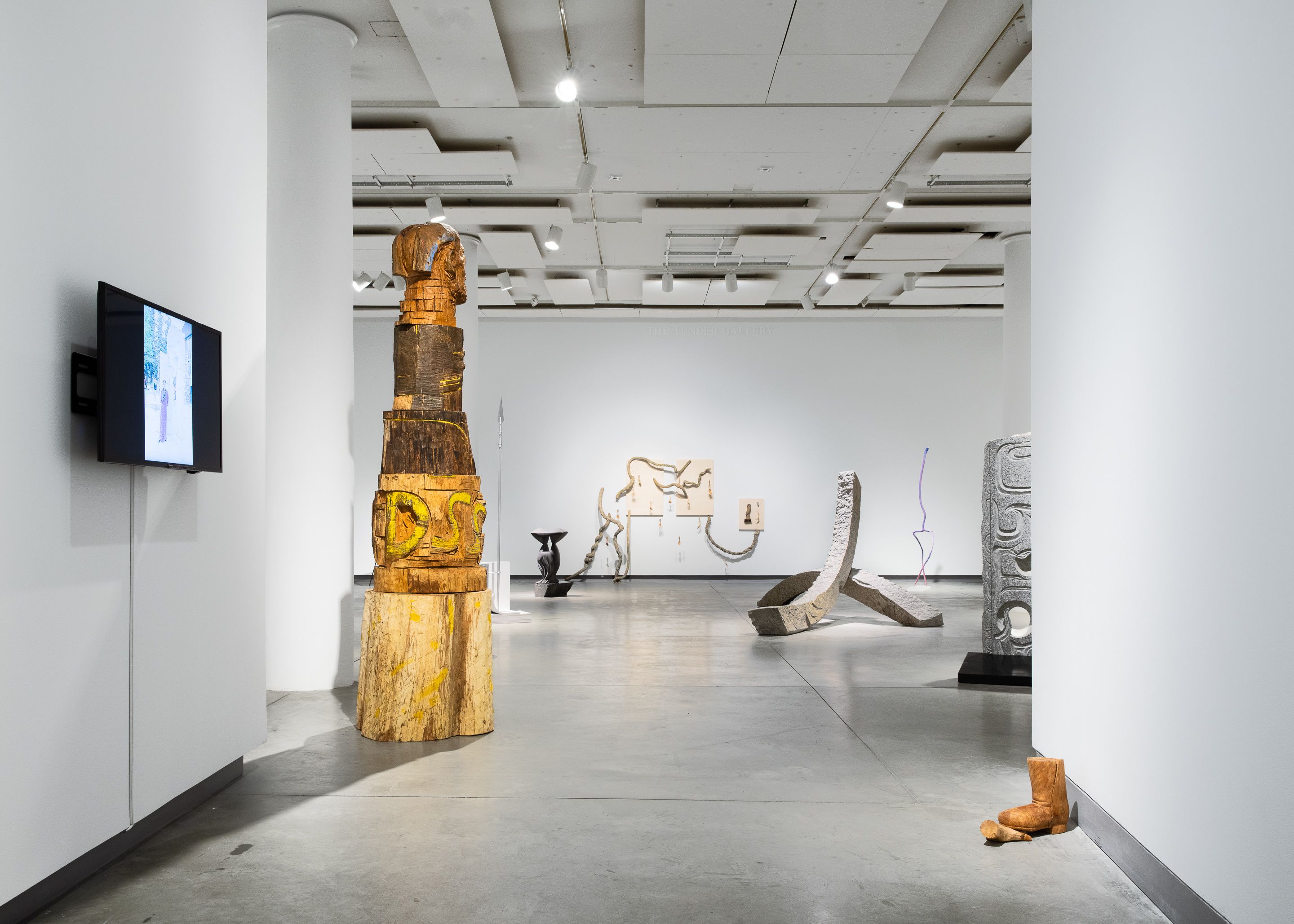 Installation view of a large totem-like wood sculpture.