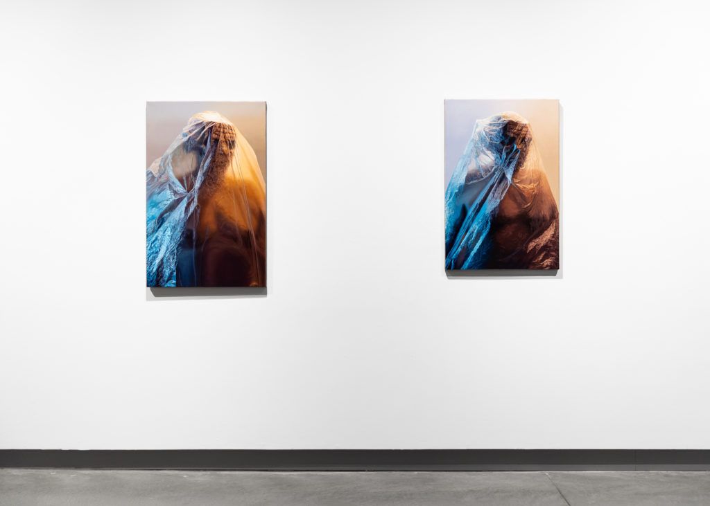 Two paintings depicting realistically rendered stoic figures beneath plastic coverings.