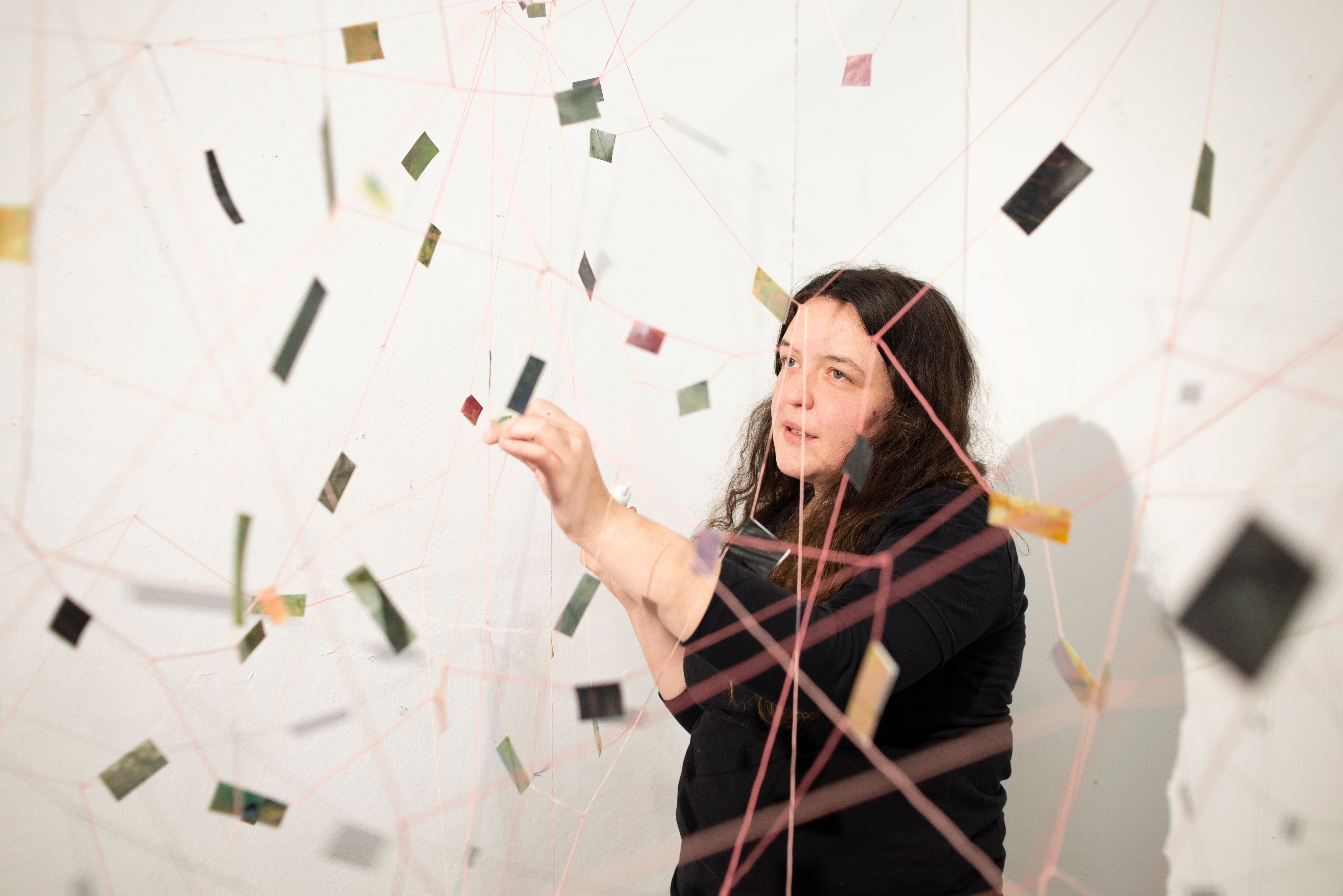 MFA Student working on a hanging string installation.