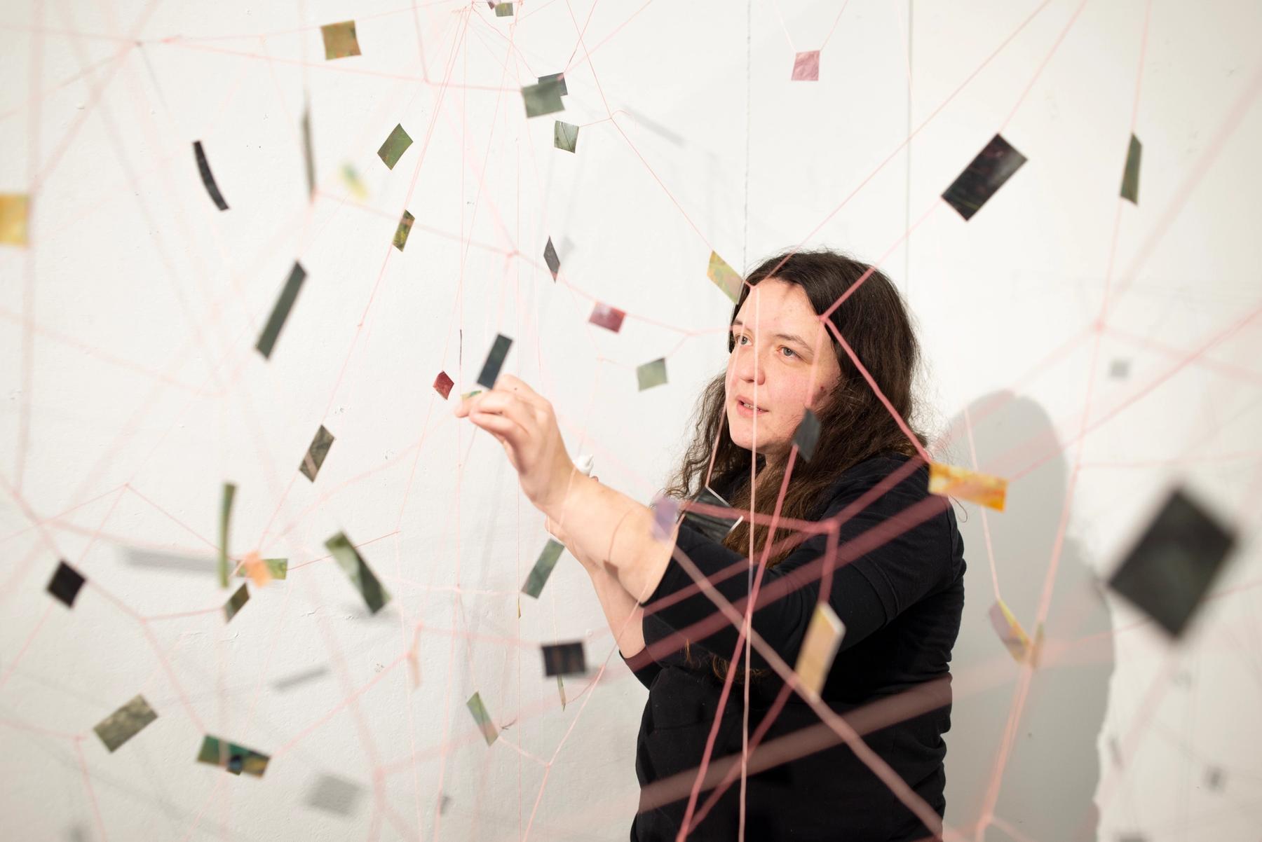 MFA Student working on a hanging string installation.