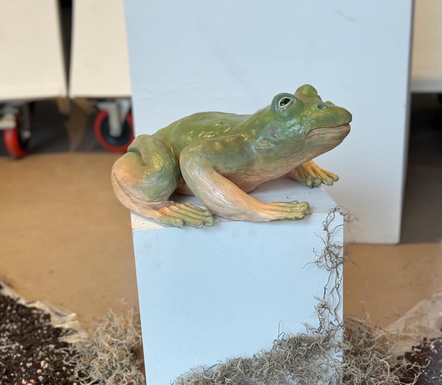 A ceramic sculpture of a frog