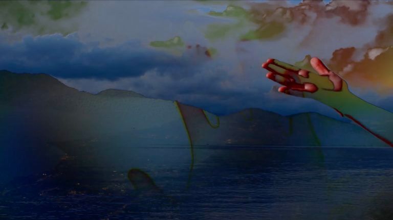 A video still depicting a color-disorted hand reaching to the sky and ocean.