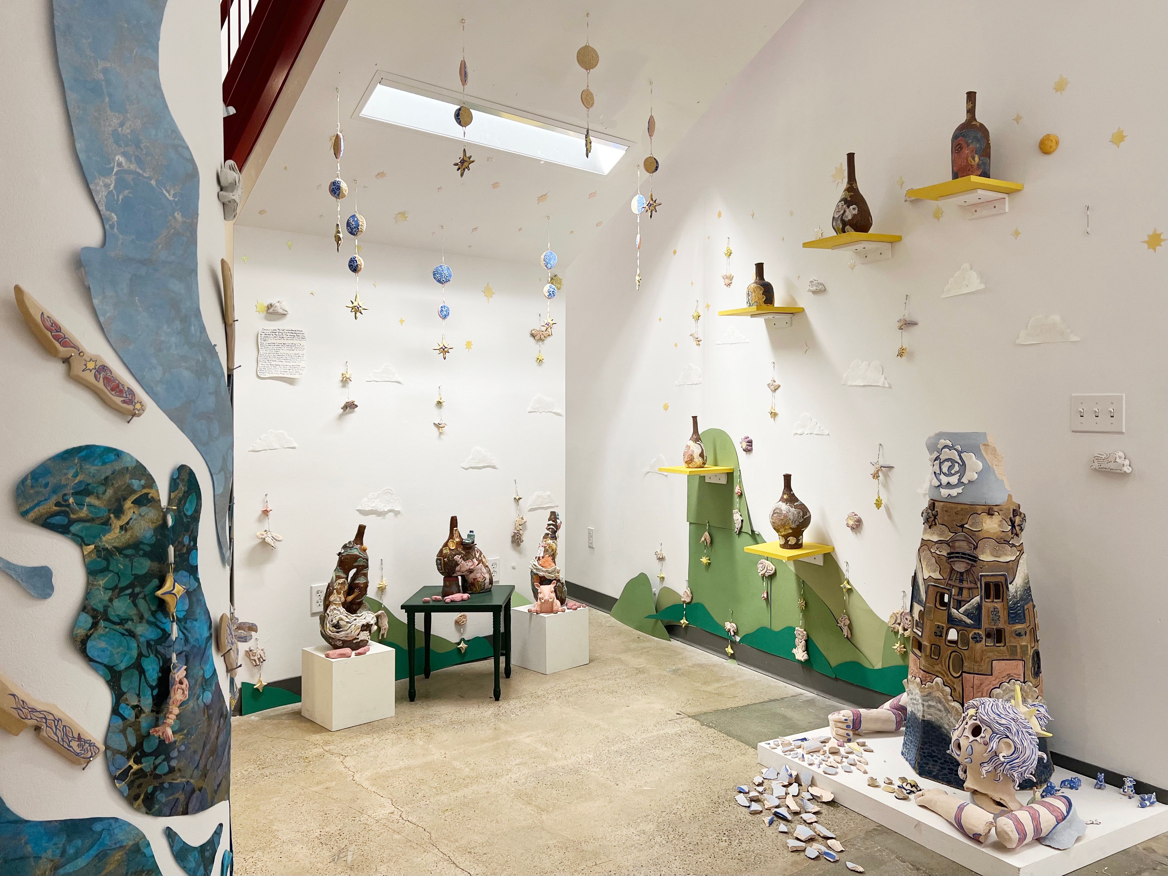 An installation of ceramic works, including vases and sculptures, with playful themes