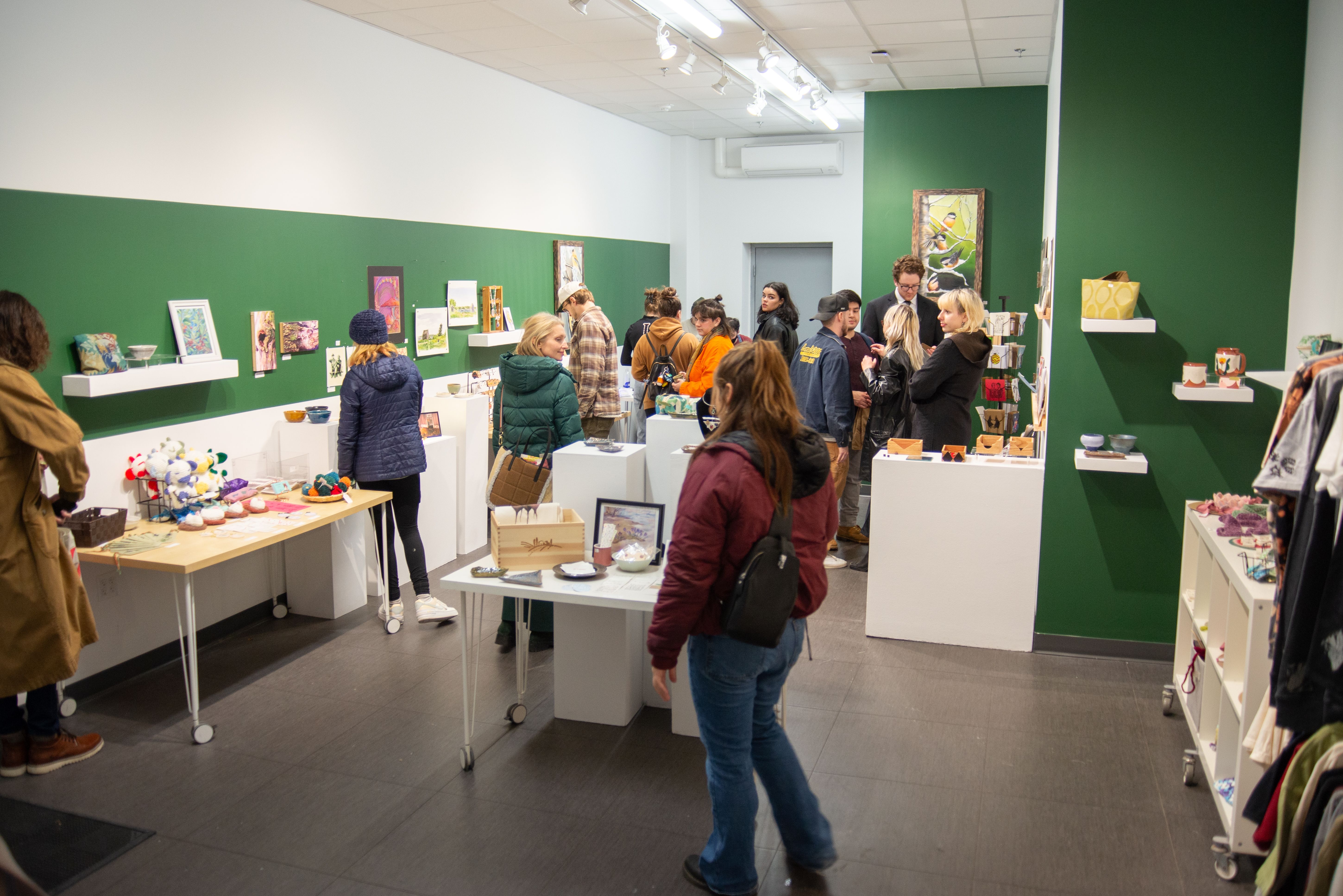 A group of people shopping for holiday gifts in the 49 Oak Gallery.