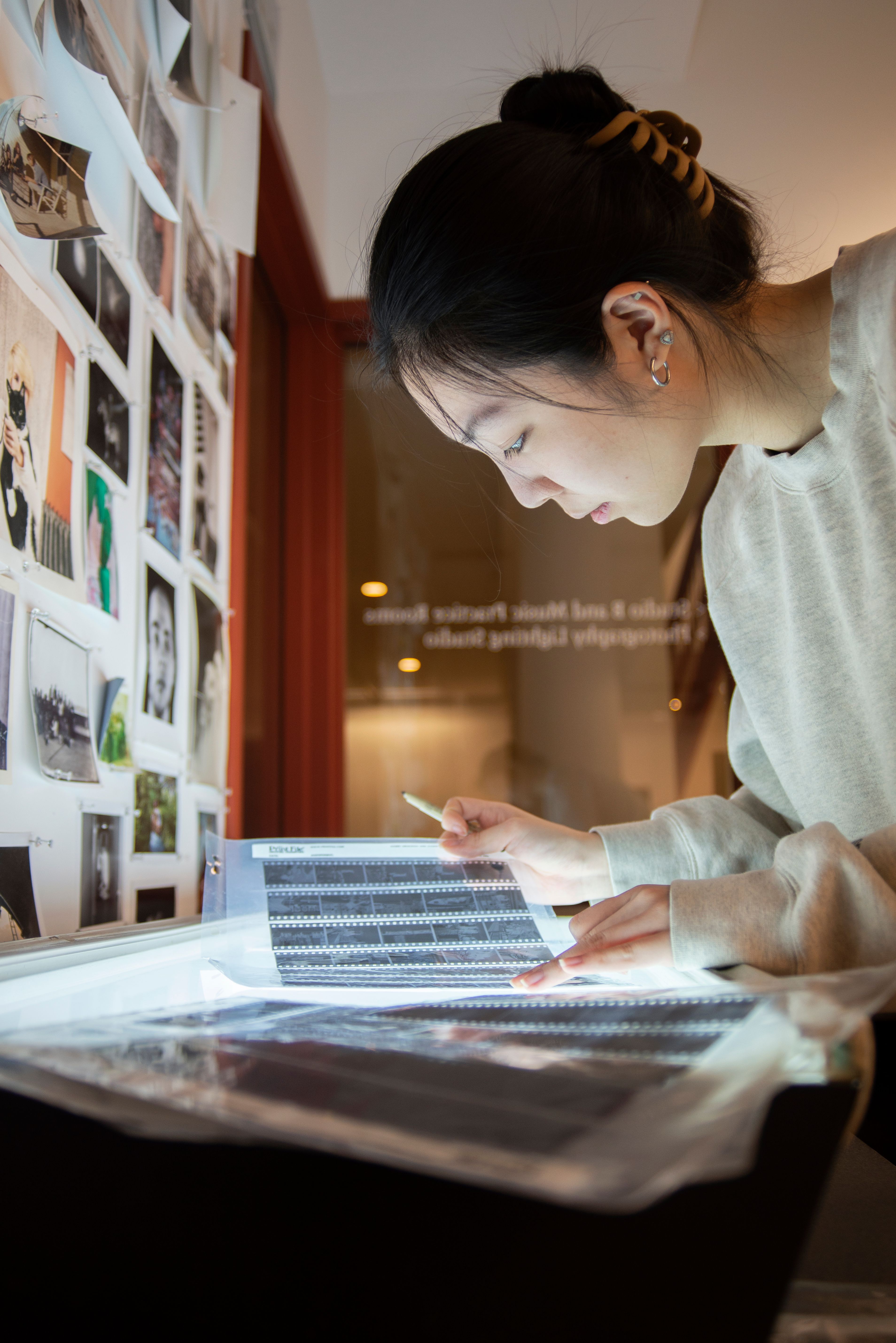 Student looking at film negatives.