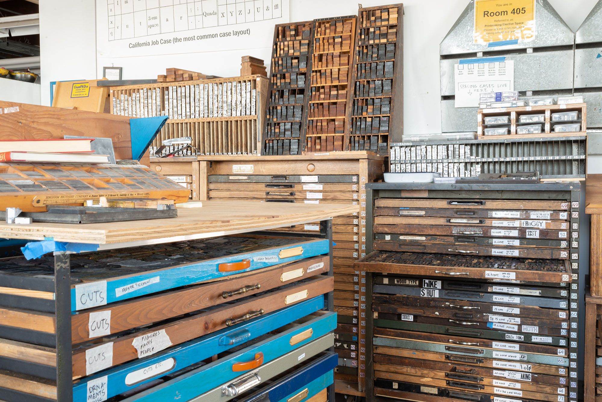 View of the letterpress section of the printmaking studio with many drawers filled with lead and wooden type.