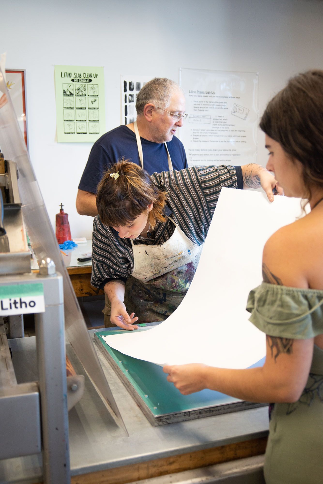 A student placing a paper on a lithography plate.