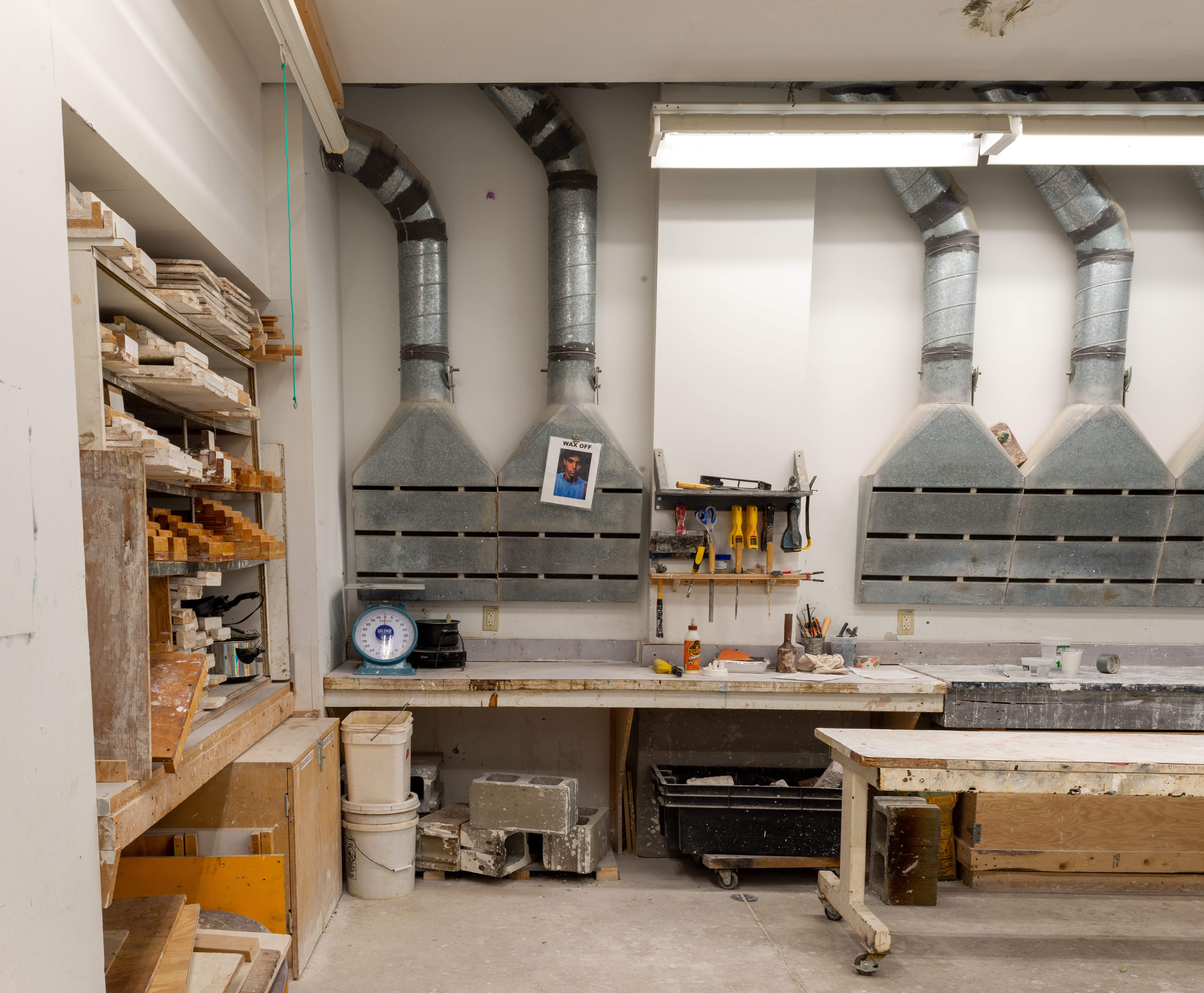 Sculpture studio space with ventilation units and tool storage.