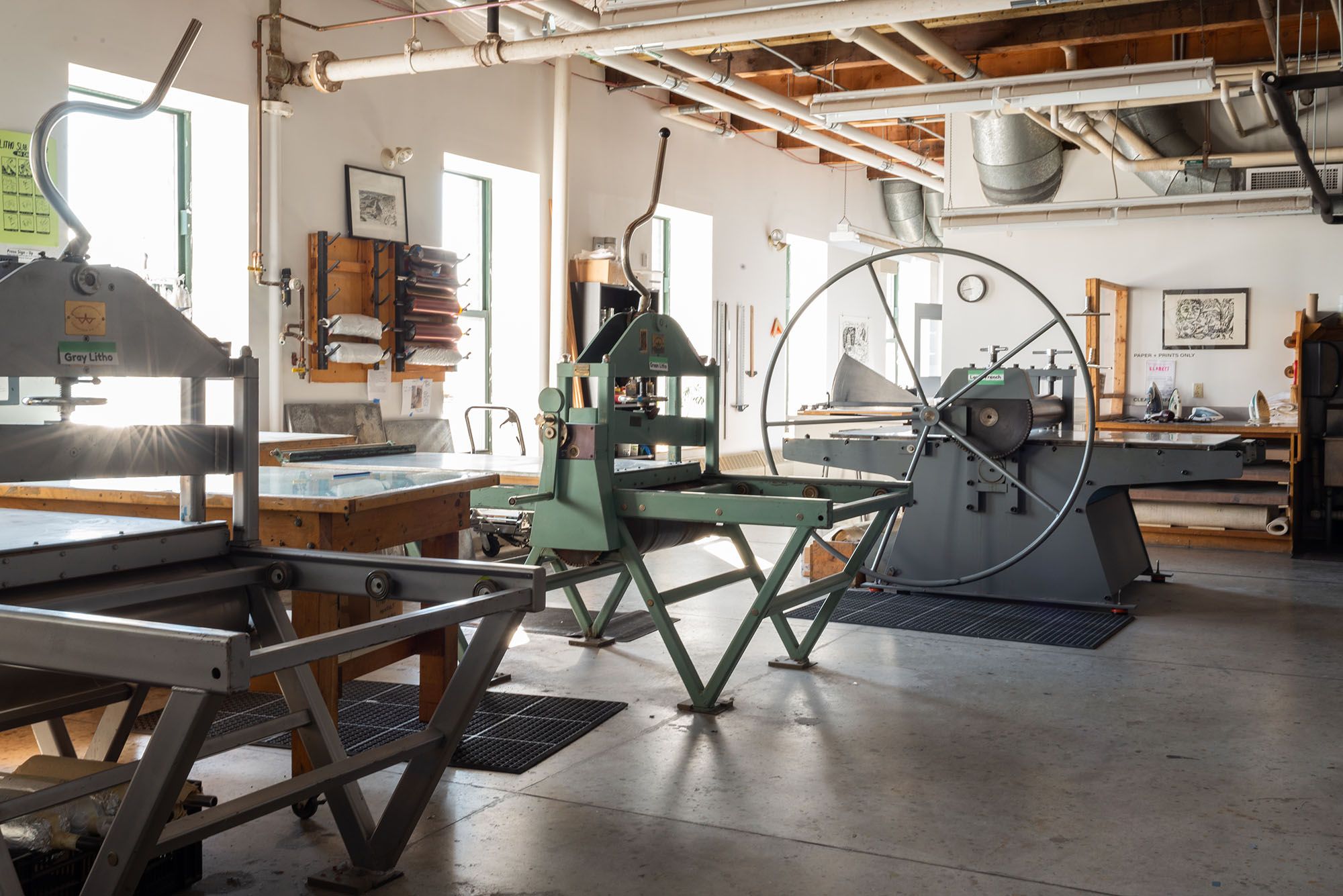 View of the printmaking studio showing two lithography presses and a large French press.