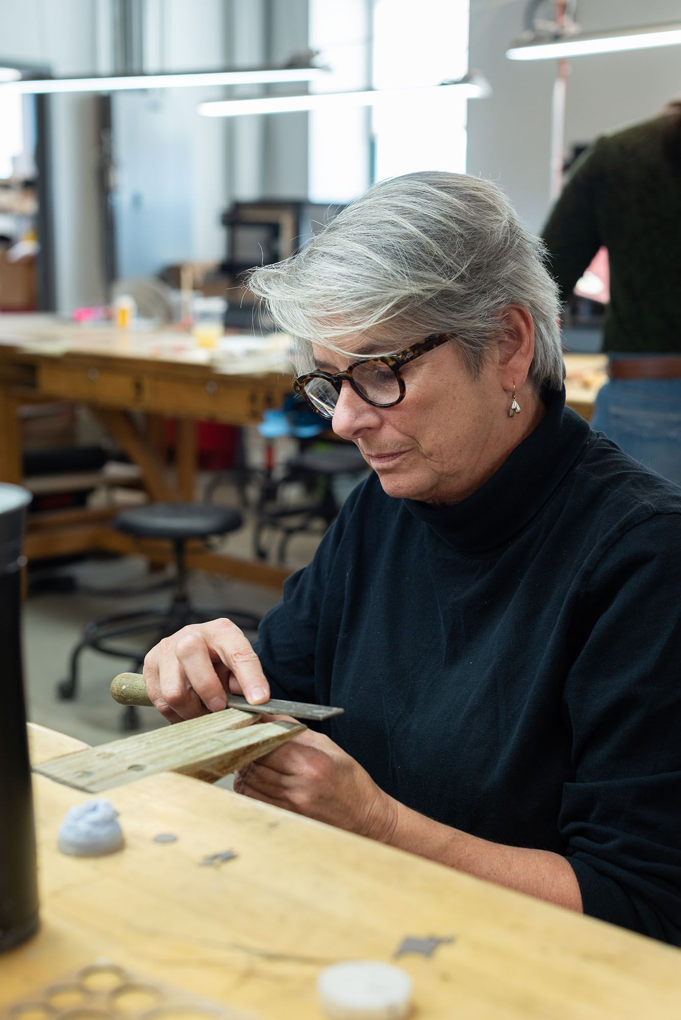 A professor demonstrating filing metal detiails.