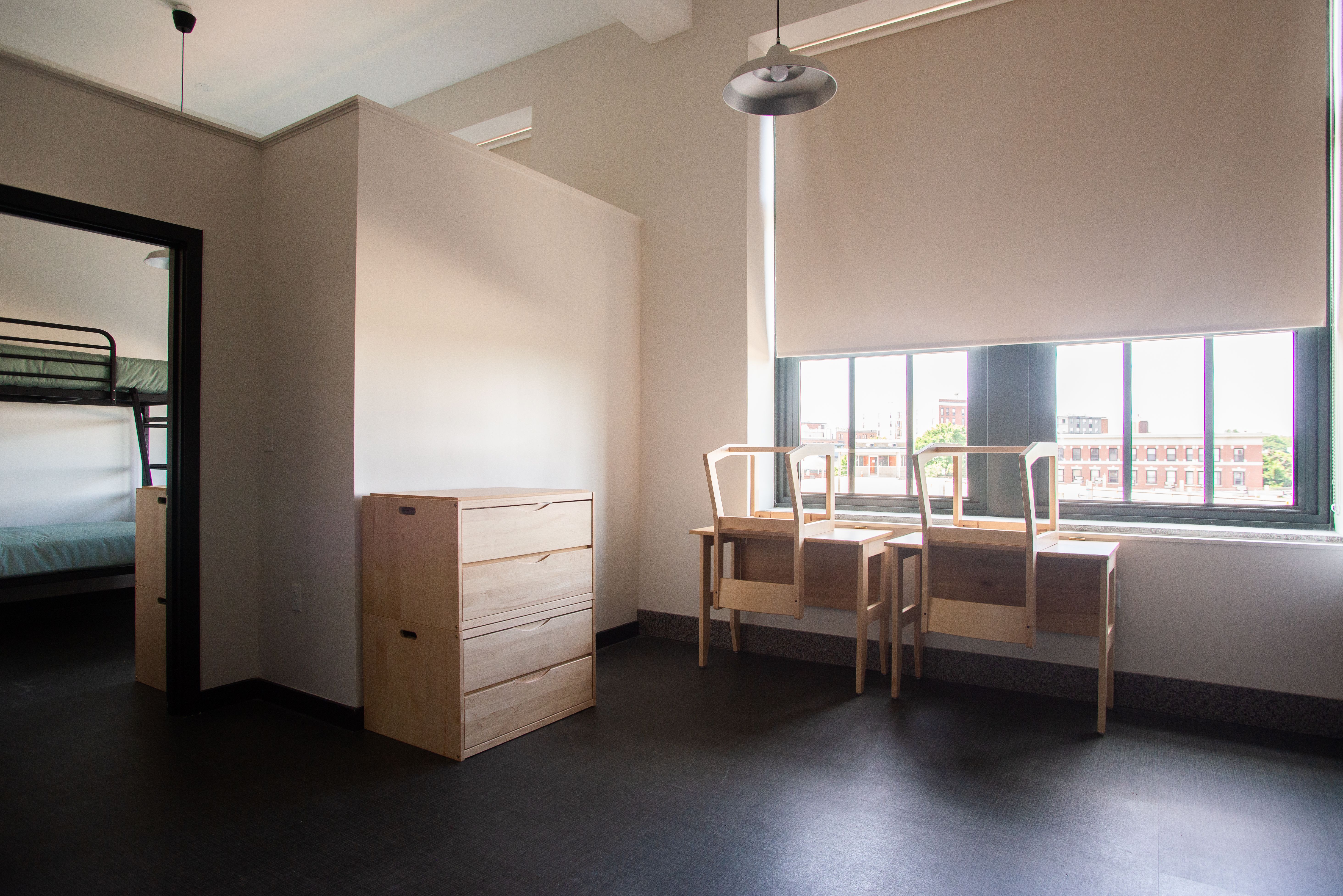 View of Erlang dorm with two desks, large windows, and an open floor plan