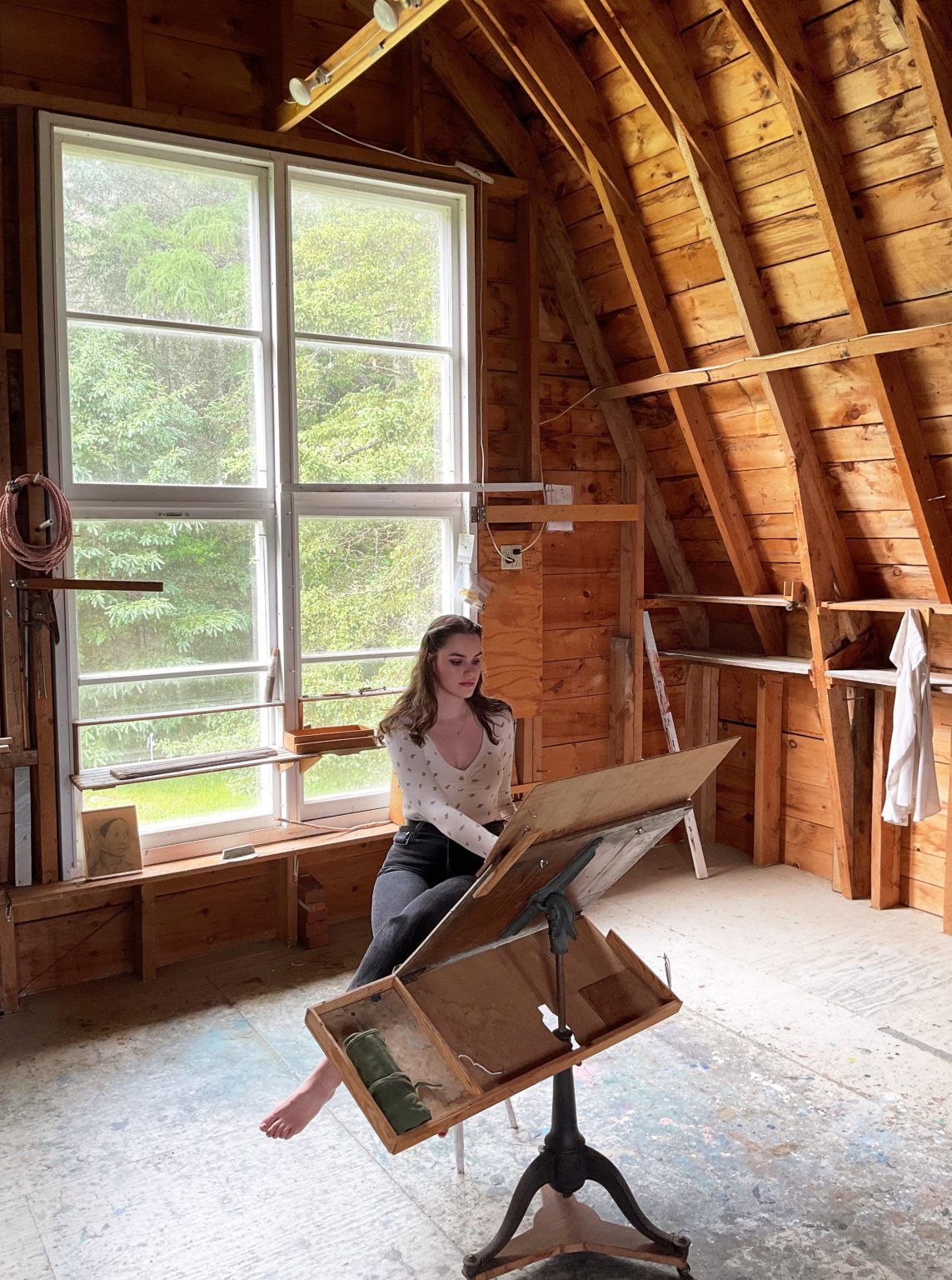 Artist working on an easel in the Pace House.