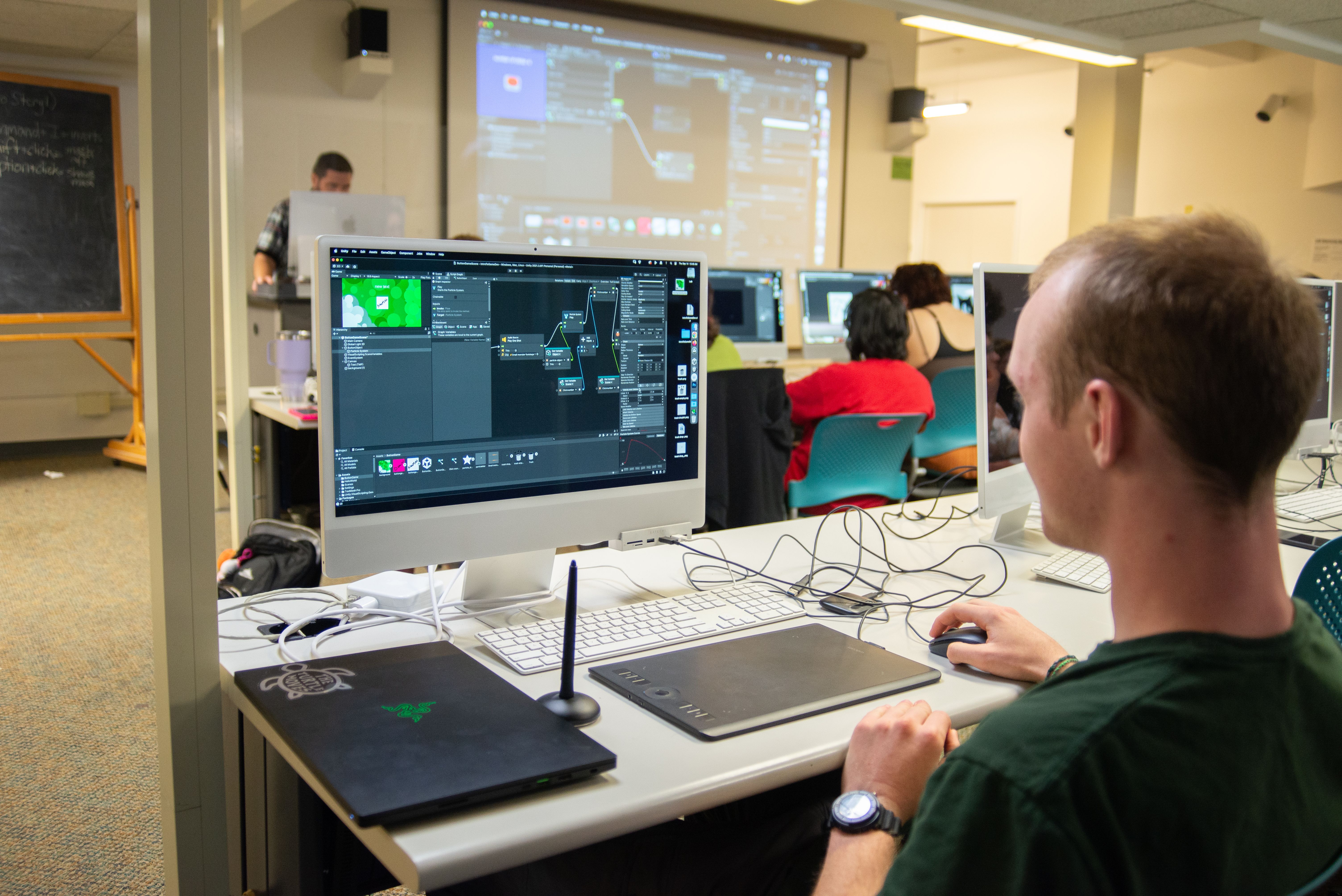 A student on a computer with a drawing tablet during a class.